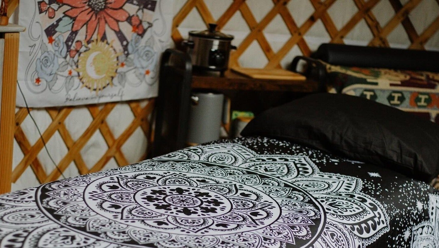 Cozy bohemian room at Wellness in the Wild, Newquay, England, GB with mandala bedding and artistic decor.