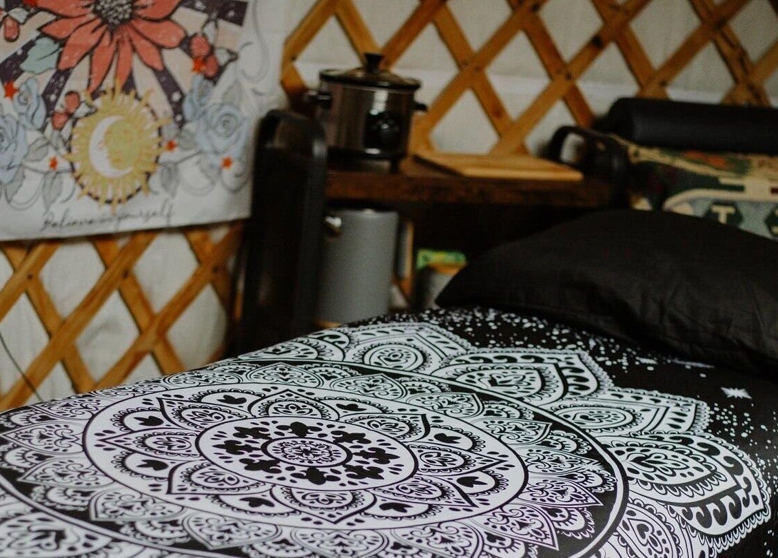 Cozy bohemian room at Wellness in the Wild, Newquay, England, GB with mandala bedding and artistic decor.