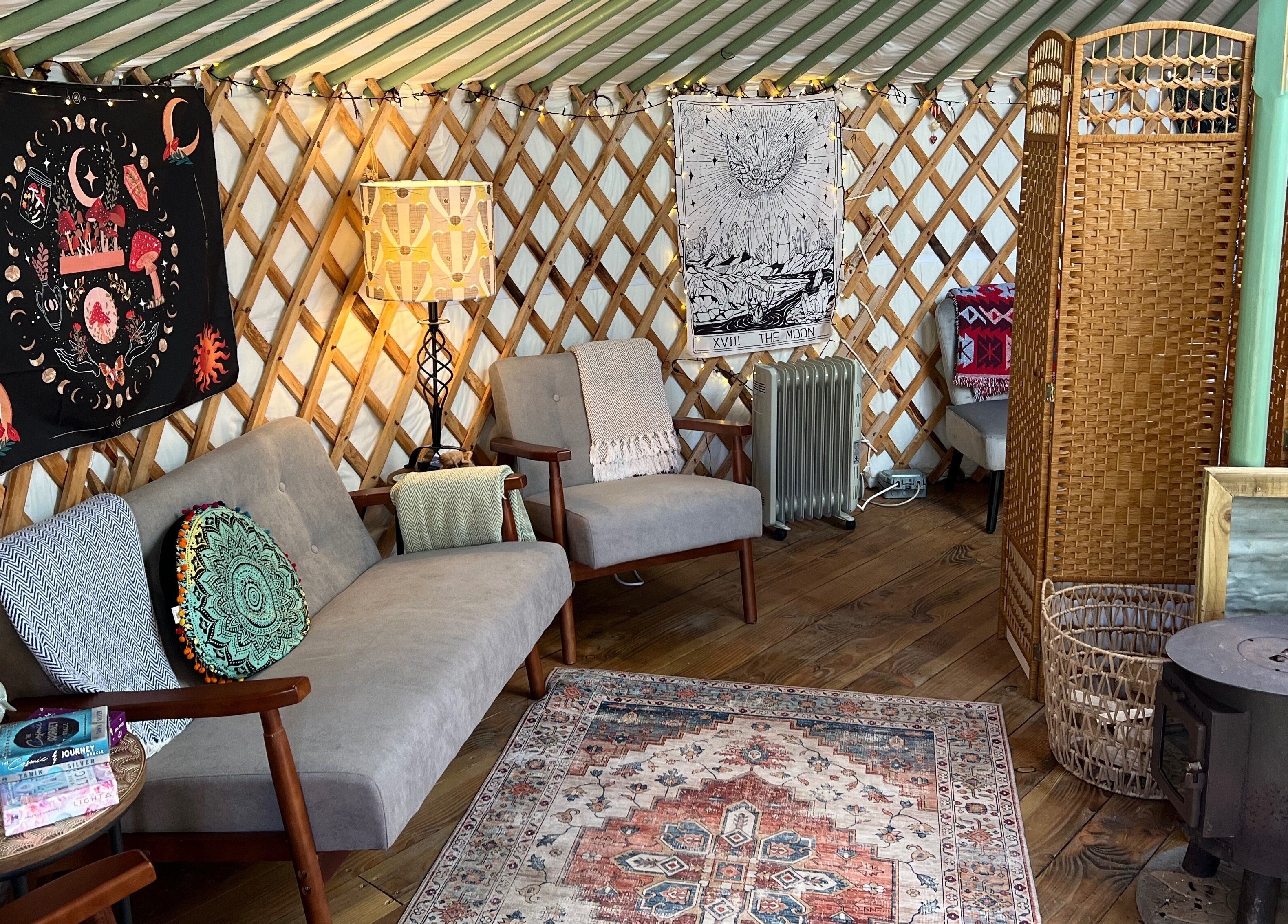 Relaxing yurt interior at Wellness in the Wild, Newquay, England, GB with cozy seating and decorative rugs.