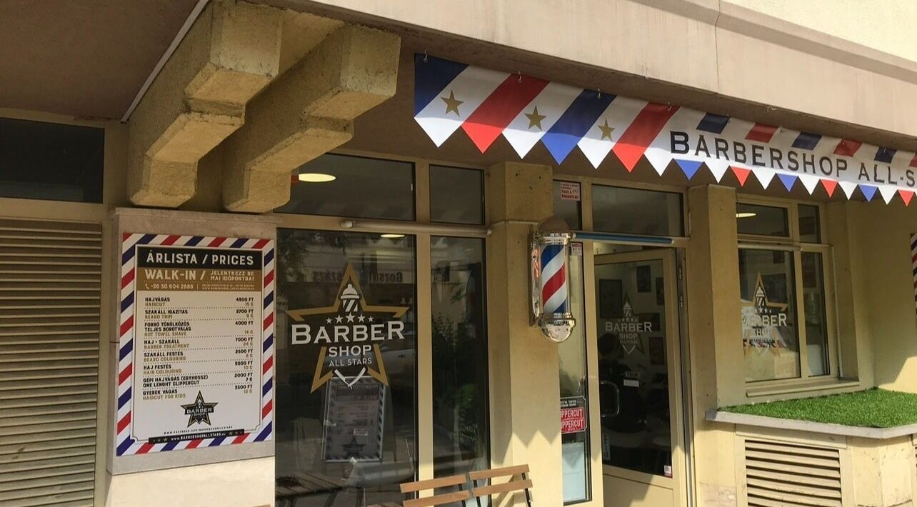A Barbershop Allstars bejárata Budapesten, Magyarországon, modern barber póllal.