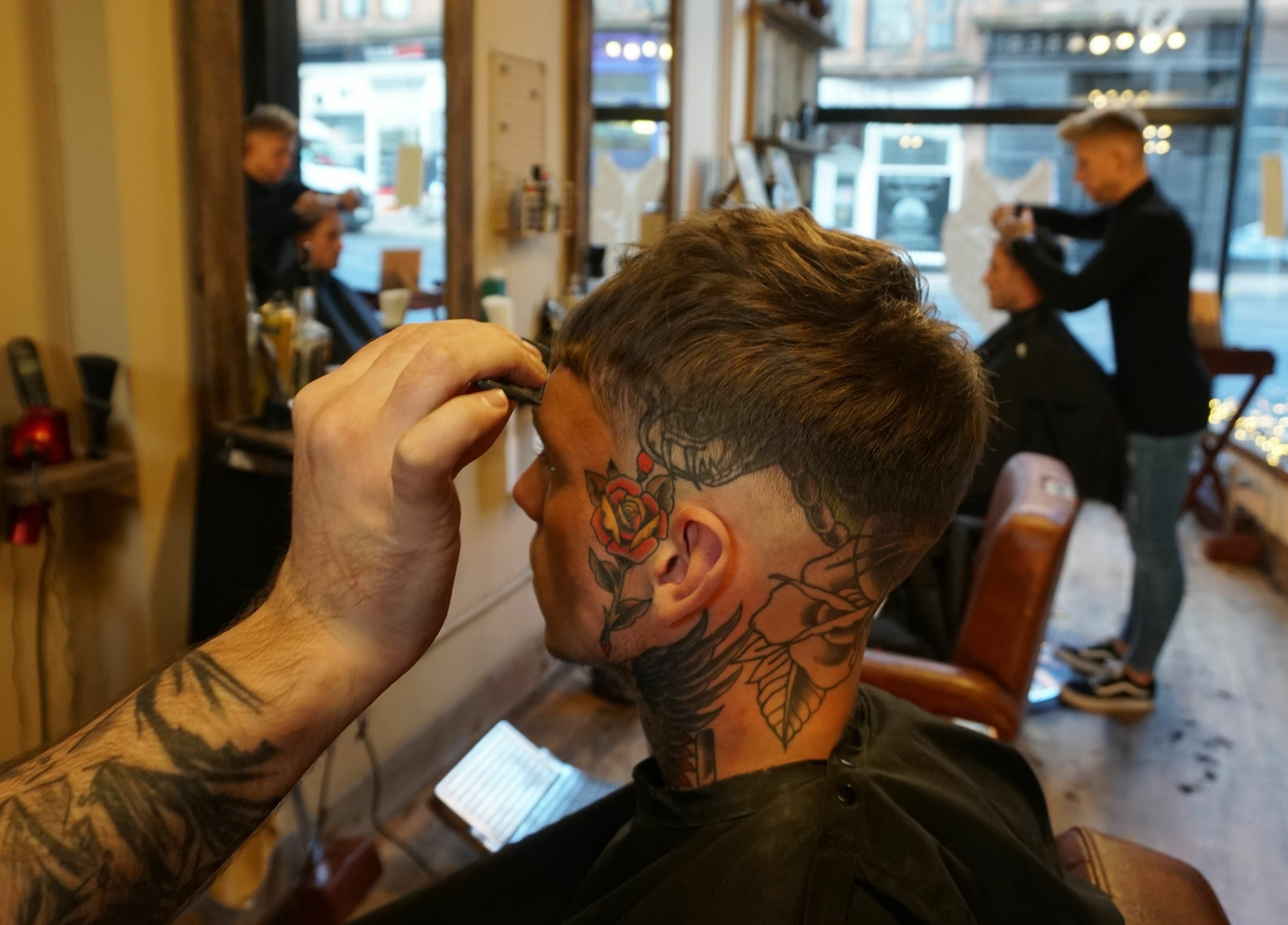 Client receives precision haircut at Dapperwolf, Glasgow, Scotland, GB, showcasing expert barber techniques.