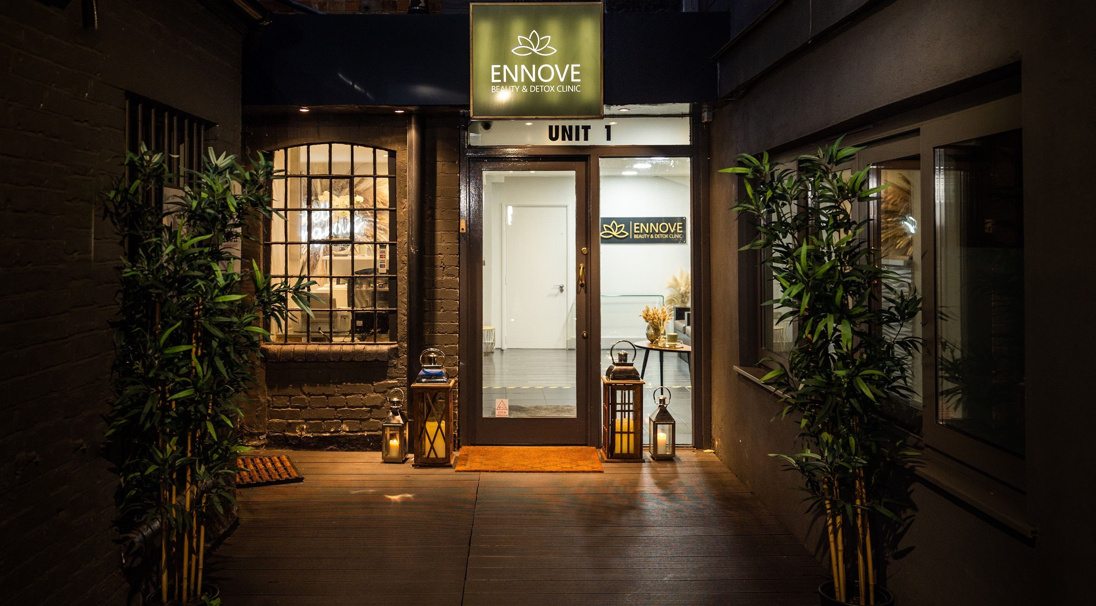 Entrance of Ennove Beauty & Detox Clinic in London, England, GB, warmly lit with plants and lanterns.