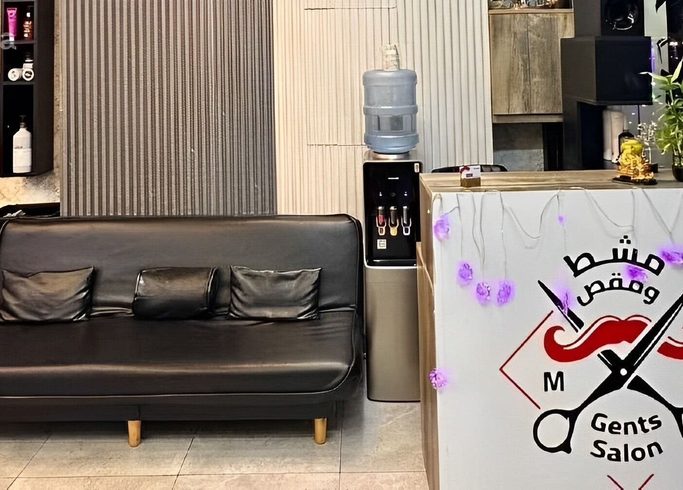 Chic interior of M&M Gents Salon in Dubai, Dubai, AE with sleek black sofa and stylish decor.