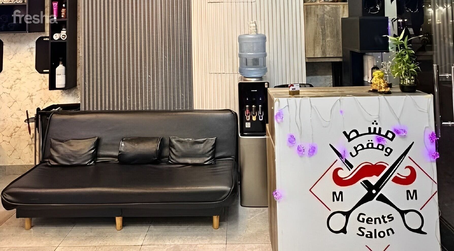 Chic interior of M&M Gents Salon in Dubai, Dubai, AE with sleek black sofa and stylish decor.