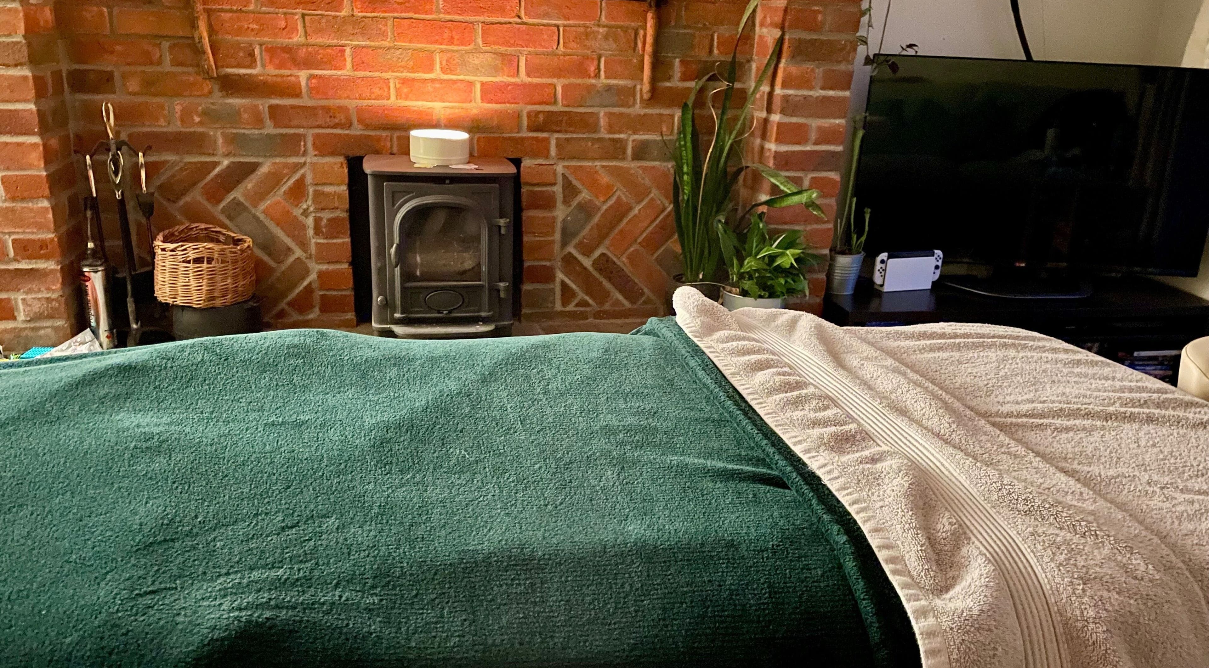Warm massage room at Amethyst Beauty and Massage, Shaftesbury, England, featuring a cozy fireplace.
