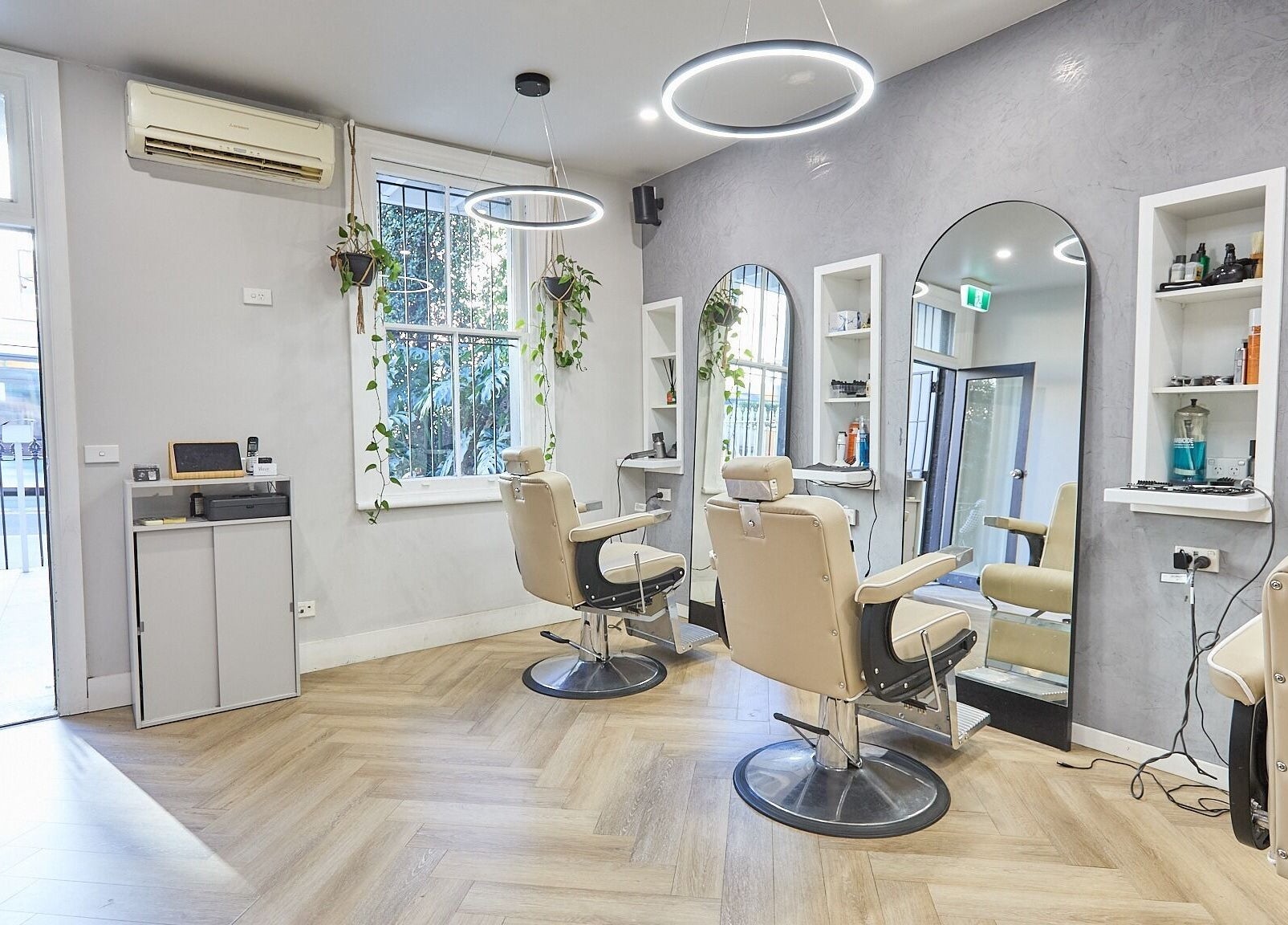 Modern interior of Verve Barbering - Surry Hills, chic chairs, mirrors, and greenery, located in Surry Hills, New South Wales, AU.