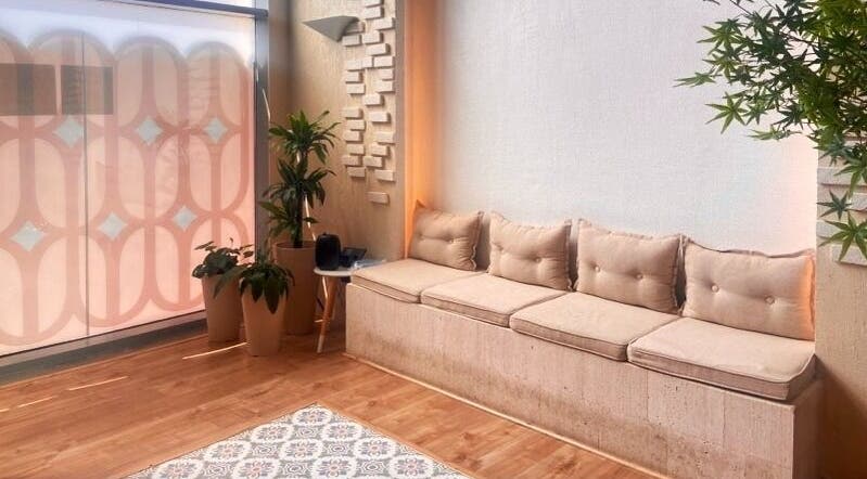 ركن الاسترخاء في صاليس سبا بدما، الشرقية، يجمع بين الأناقة والراحة مع وسائد مريحة ونباتات خضراء.