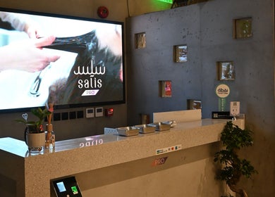 رف استقبال في صالون ساليس برو، الدمام، الشرقية، بالزهور الطبيعية وأعمال فنية جدارية.