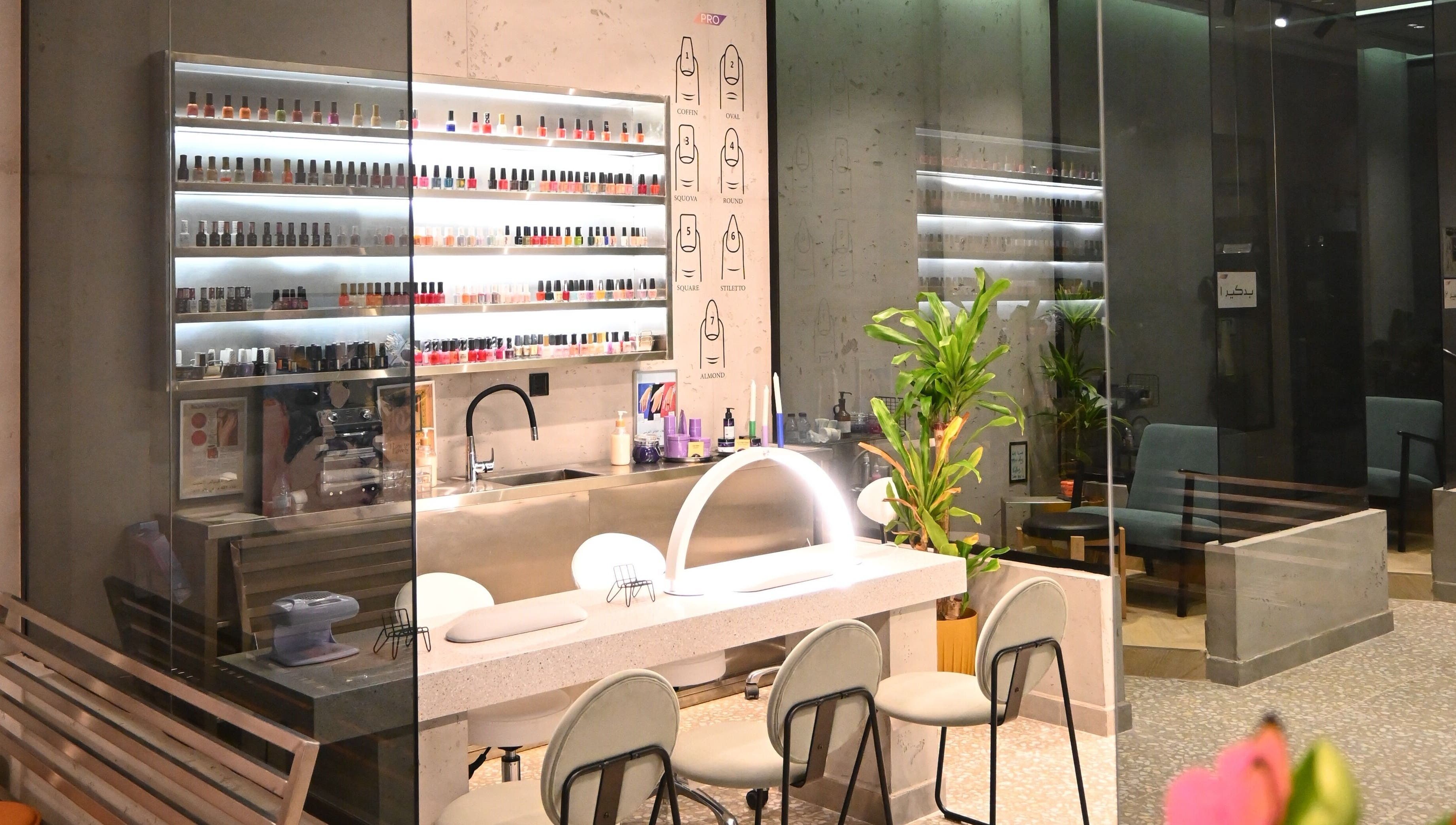 ديكور صالون حديث في صاليس برو، الدمام، يشمل منطقة تجميل وأرفف طلاء الأظافر.