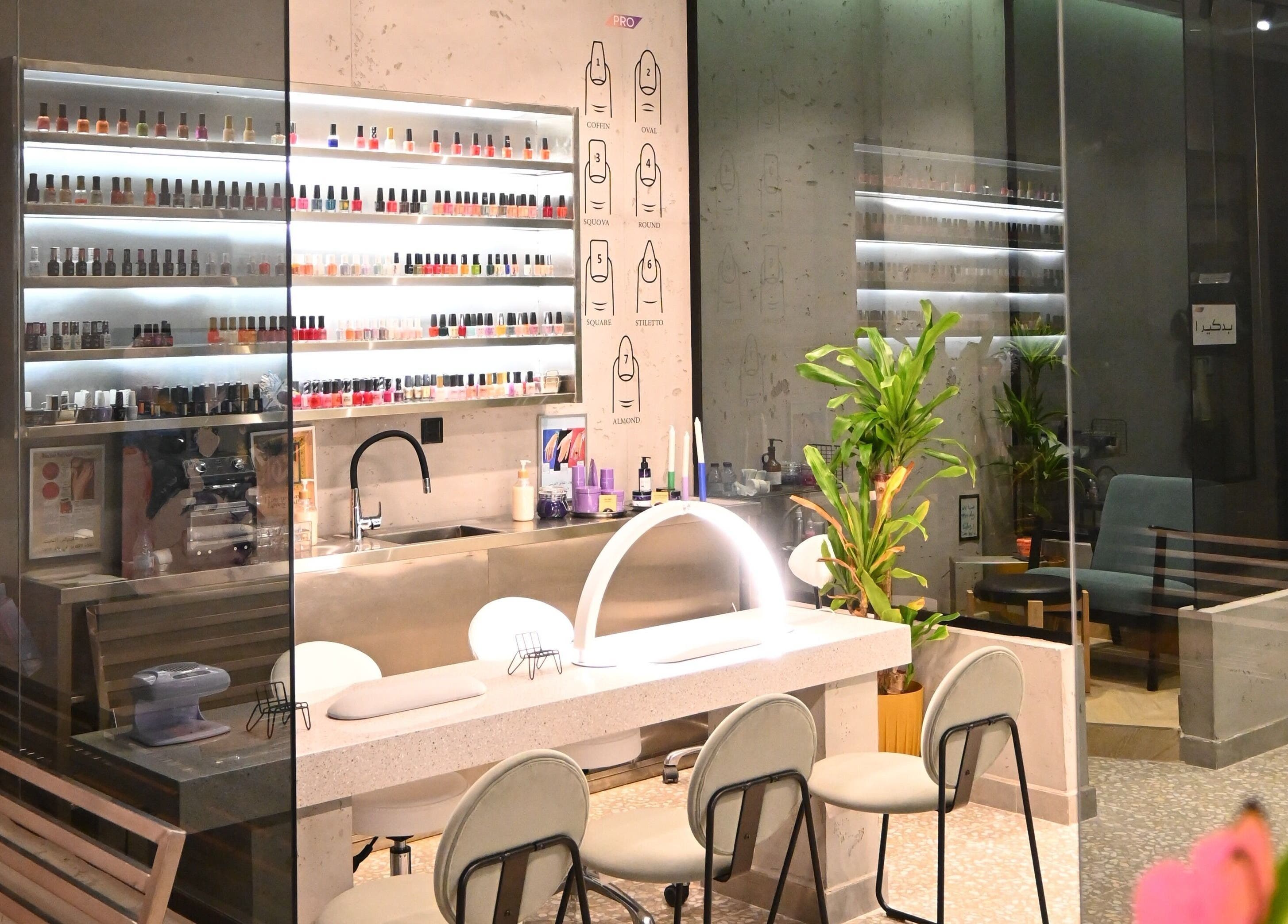 ديكور صالون حديث في صاليس برو، الدمام، يشمل منطقة تجميل وأرفف طلاء الأظافر.