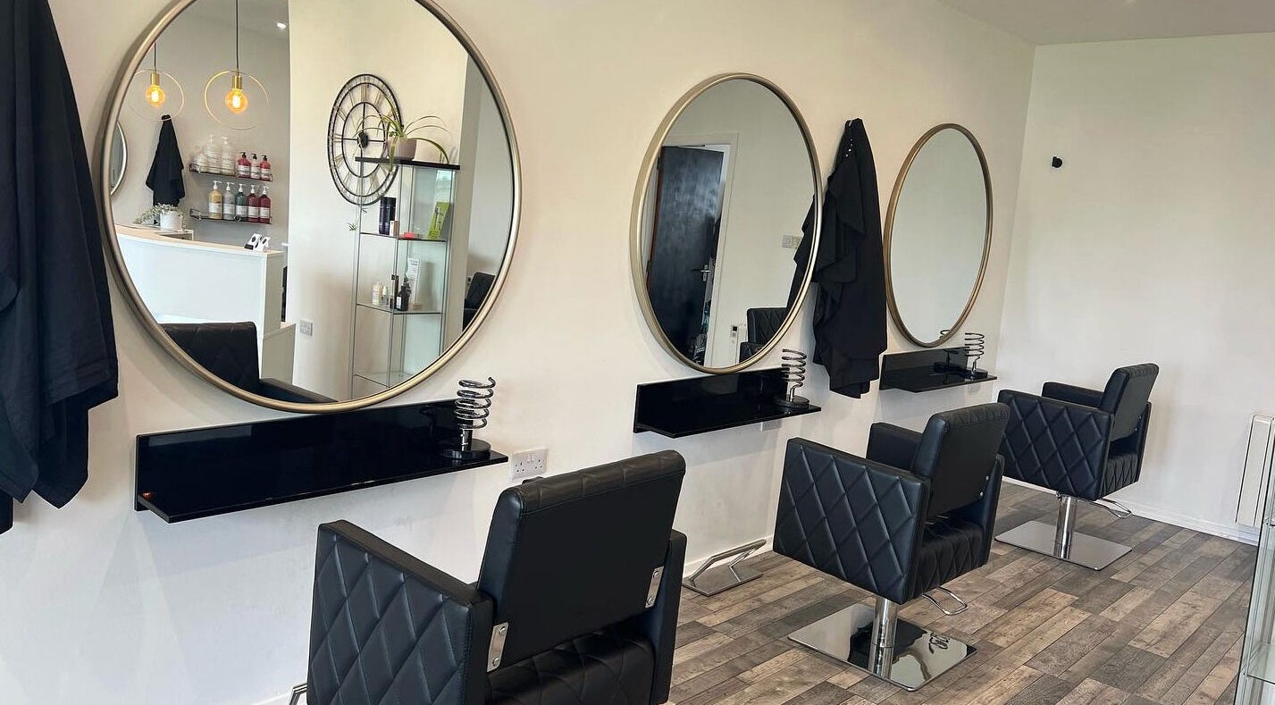 Adore Hair & Beauty in Portlethen, Scotland features elegant mirrors and styling chairs, creating a chic salon ambiance.