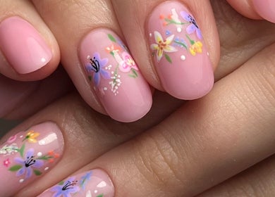 Elegant floral nail art at MKM Beauty, Lancaster, England, GB, showcasing intricate designs in pinks and purples.