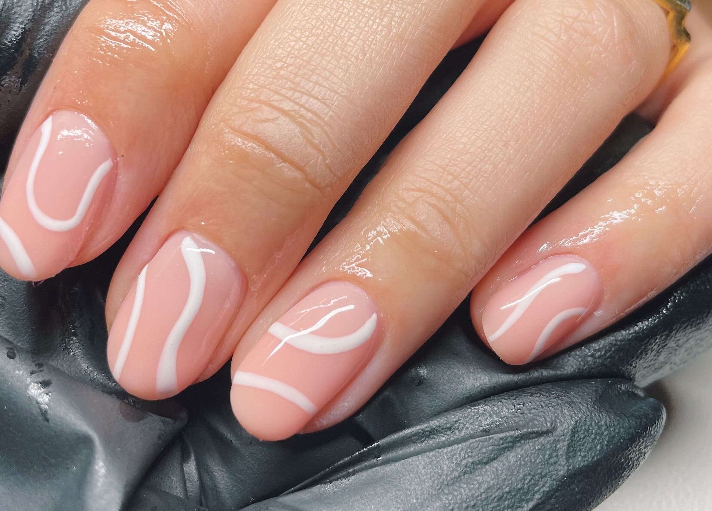 Elegant pink nails with white design at The Cure, Stockport, England, GB.