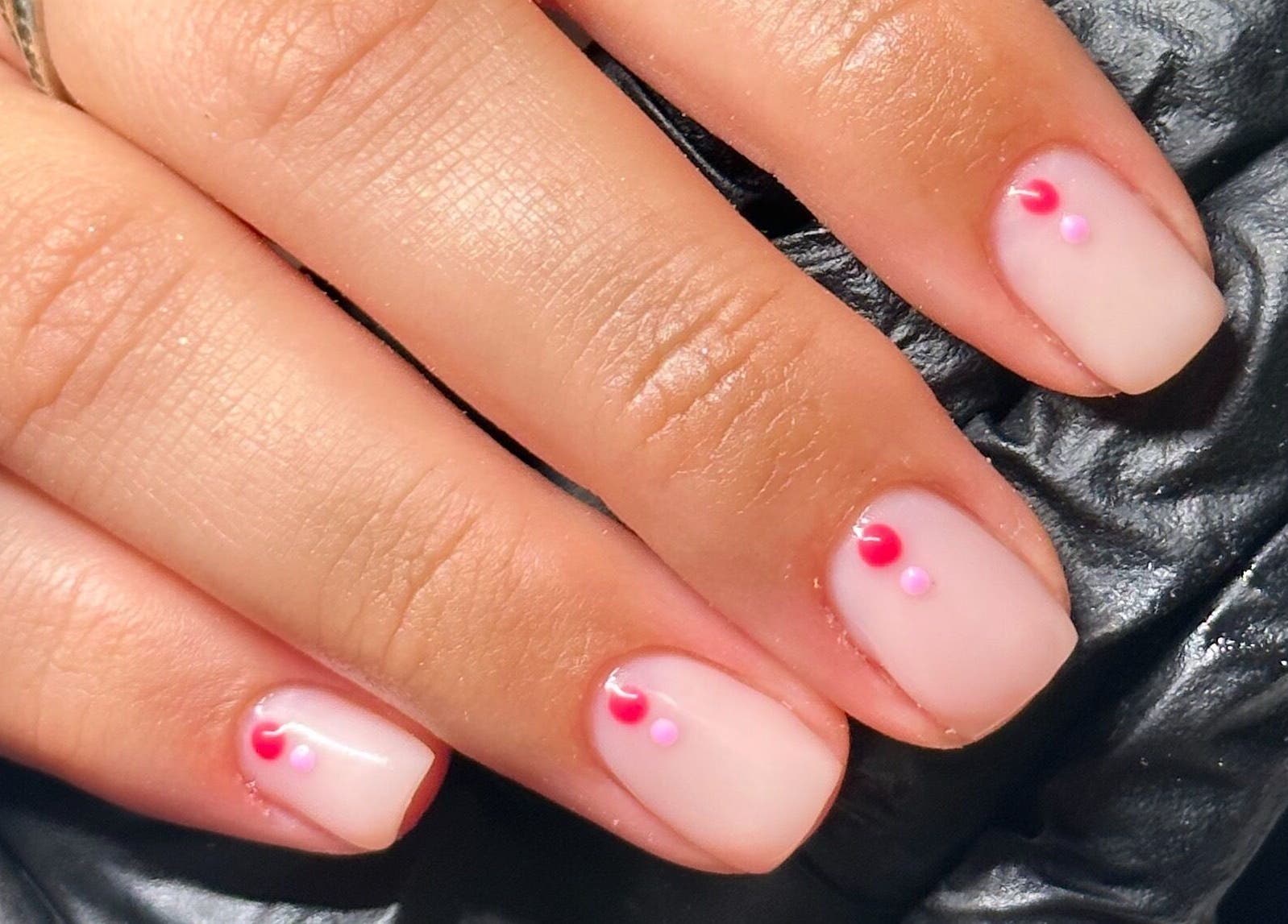 Stylish nail art with pink and red dots at The Cure, Stockport, England, GB.