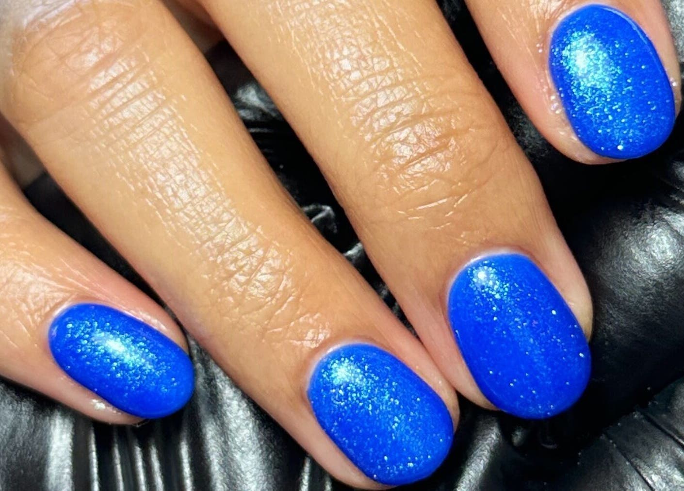 Vibrant blue manicured nails at The Cure, Stockport, England, GB. Perfect for a chic look.
