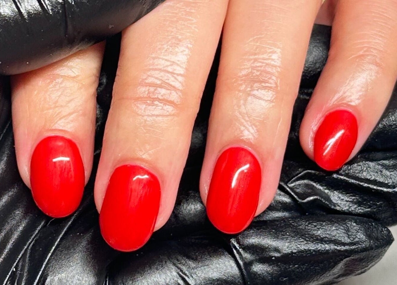 Vibrant red nails freshly manicured at The Cure, Stockport, England, GB, showcasing professional nail care.