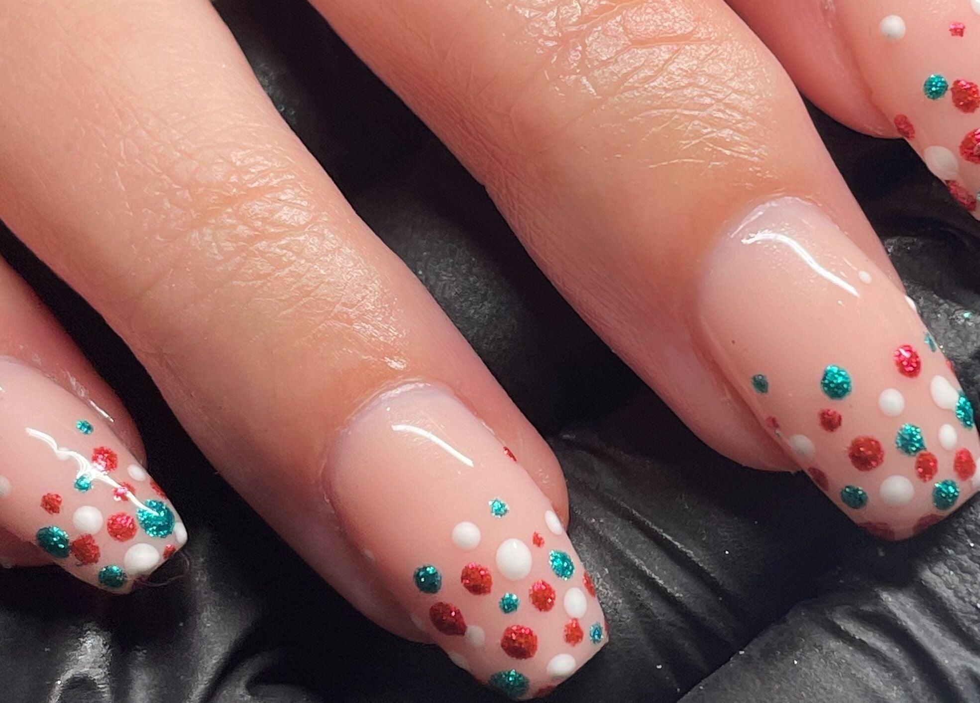 Polka dot nail art at The Cure in Stockport, England, GB showcasing vibrant red and teal designs.