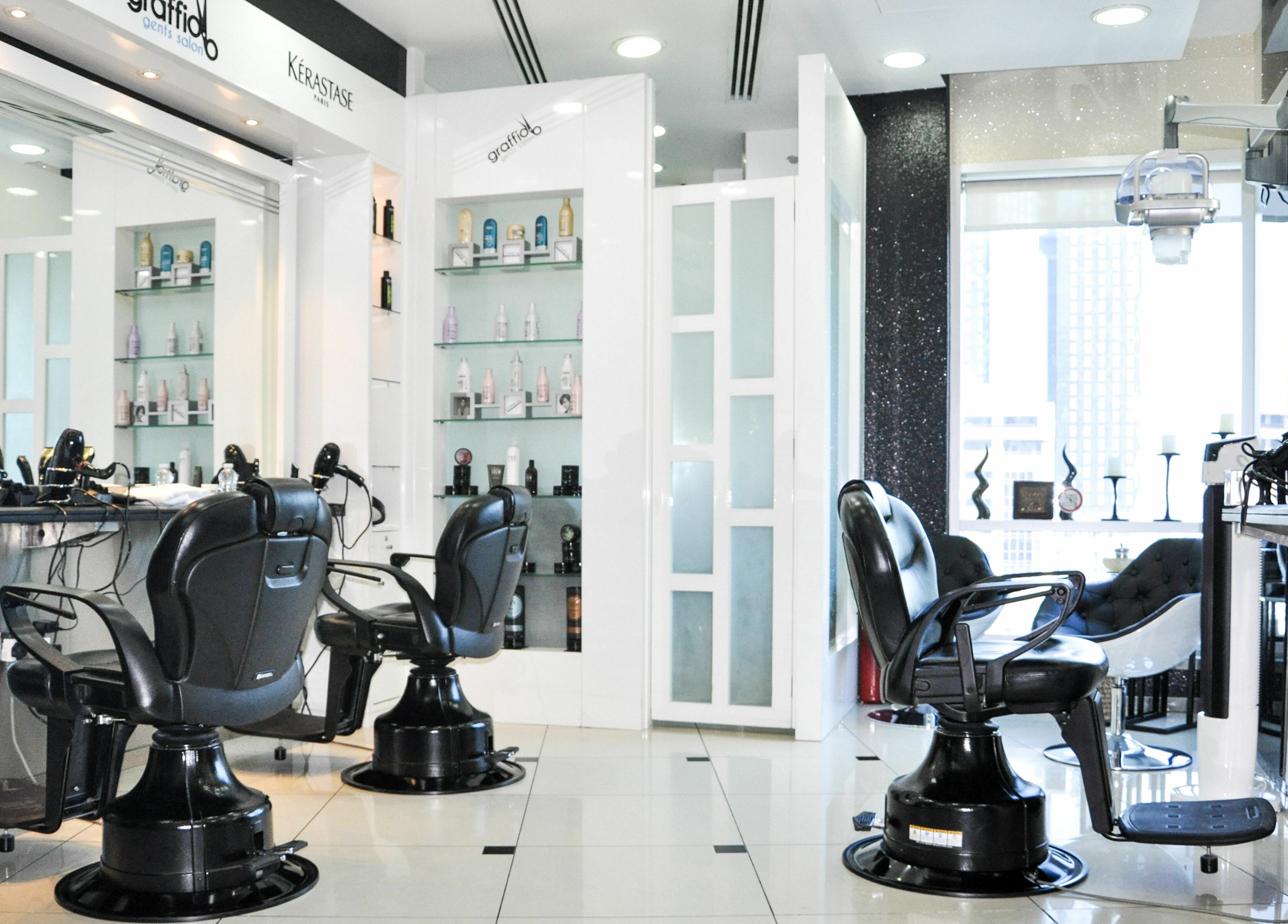 Modern interior of Graffio Gents Salon - Shangri-La Hotel in Dubai, AE, featuring sleek barber chairs and styling stations.