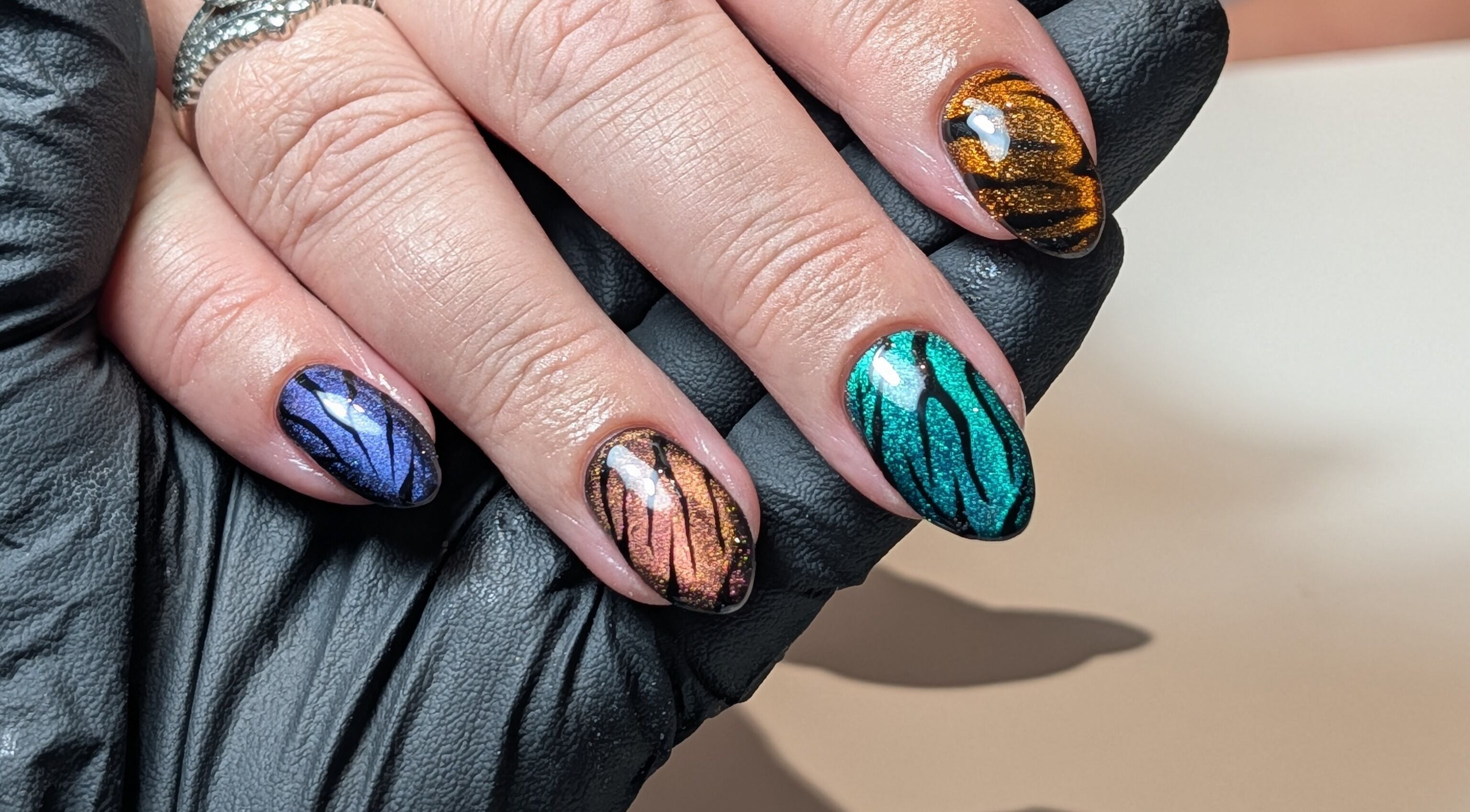 Vibrant butterfly nail art at The Beauty Shack in Redcar, England, GB, showcasing colorful intricate designs.