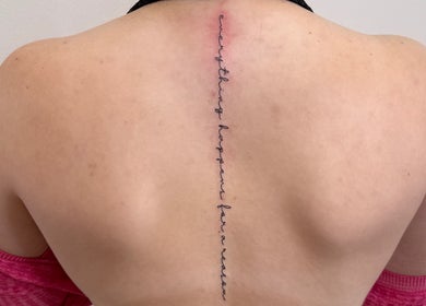 Vertical line tattoo on back with script at Ray of Beauty LLC, Chillicothe, Ohio, US.