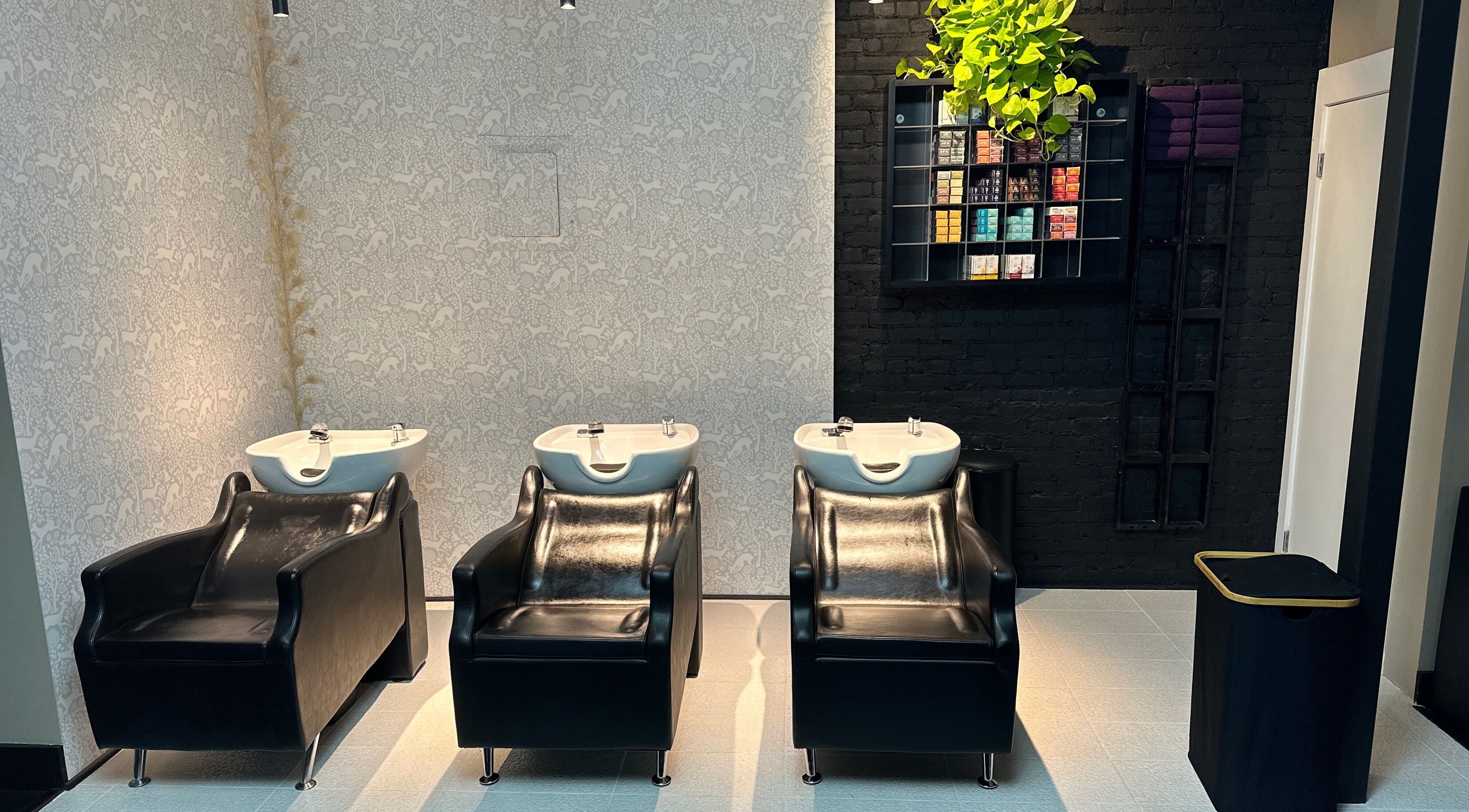 Luxurious wash stations at Oshun’s Crown, New York, New York, US, highlighting sleek black chairs and modern design.