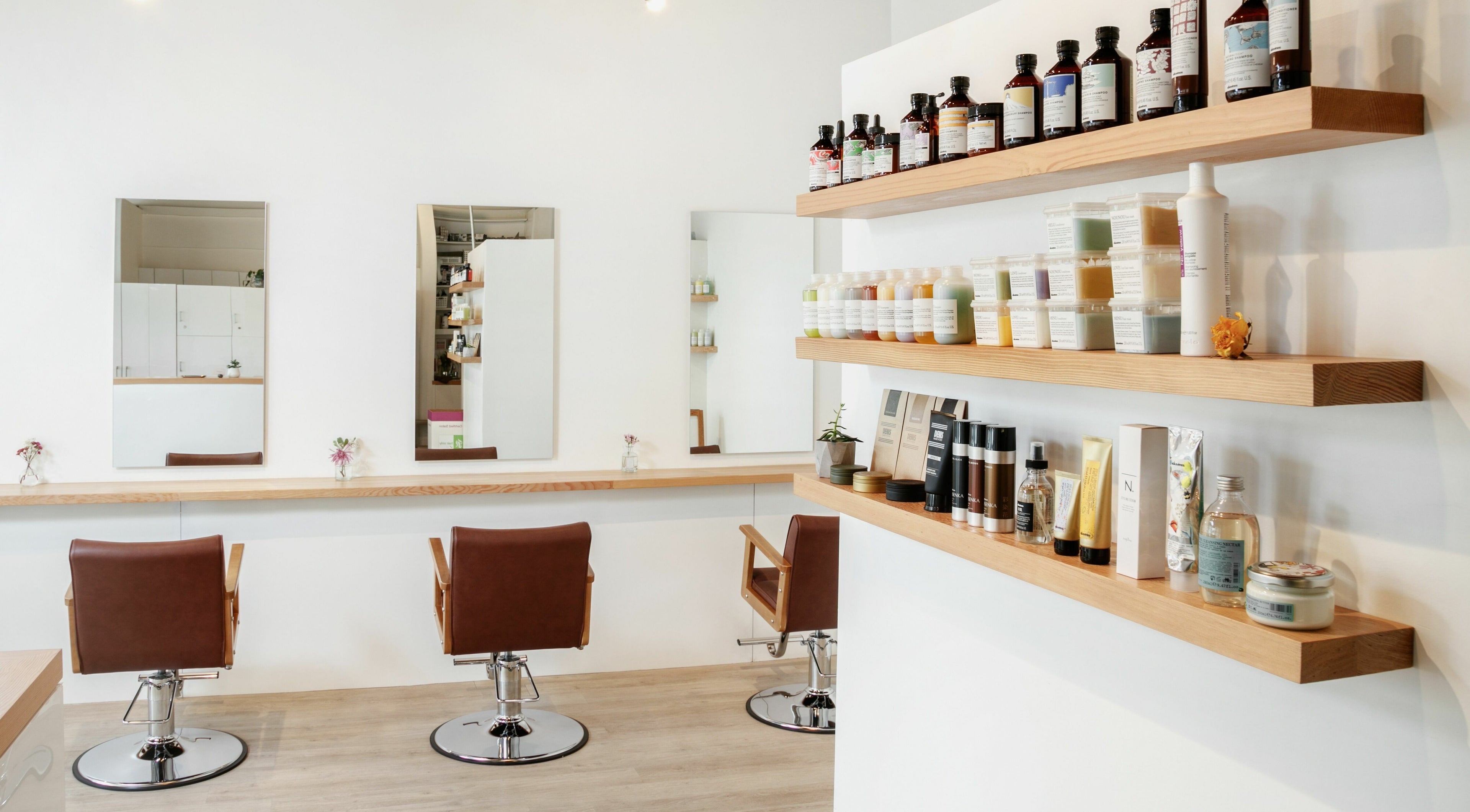 Stylish interior of Forme Hair Salon, Broadway in Vancouver, BC, CA featuring modern chairs and product shelves.