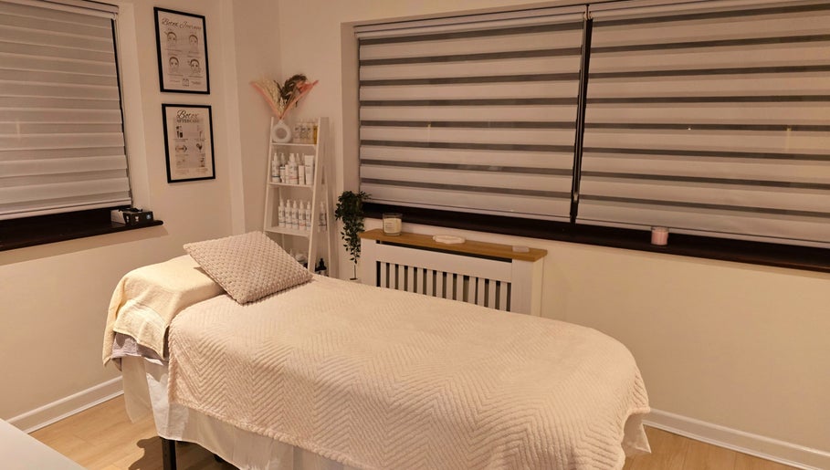 Cozy treatment room at Naked Glow Clinic, Hartland, England, featuring a restful bed and soothing decor.