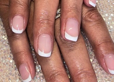 Manicured hands with French tips at Naked Glow Clinic in Hartland, England, GB, showcasing refined nail artistry.