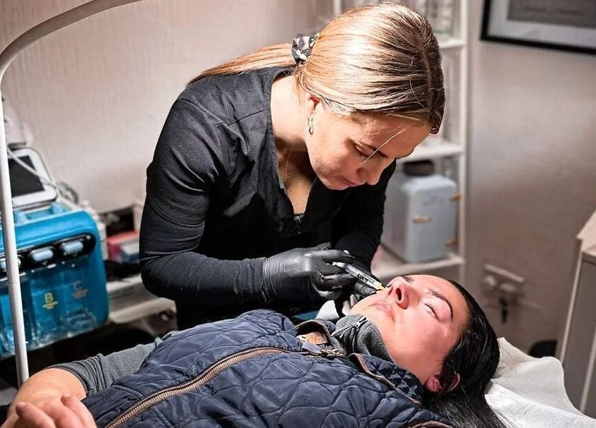 Skilled professional performing beauty treatment at Naked Glow Clinic, Hartland, England, GB.