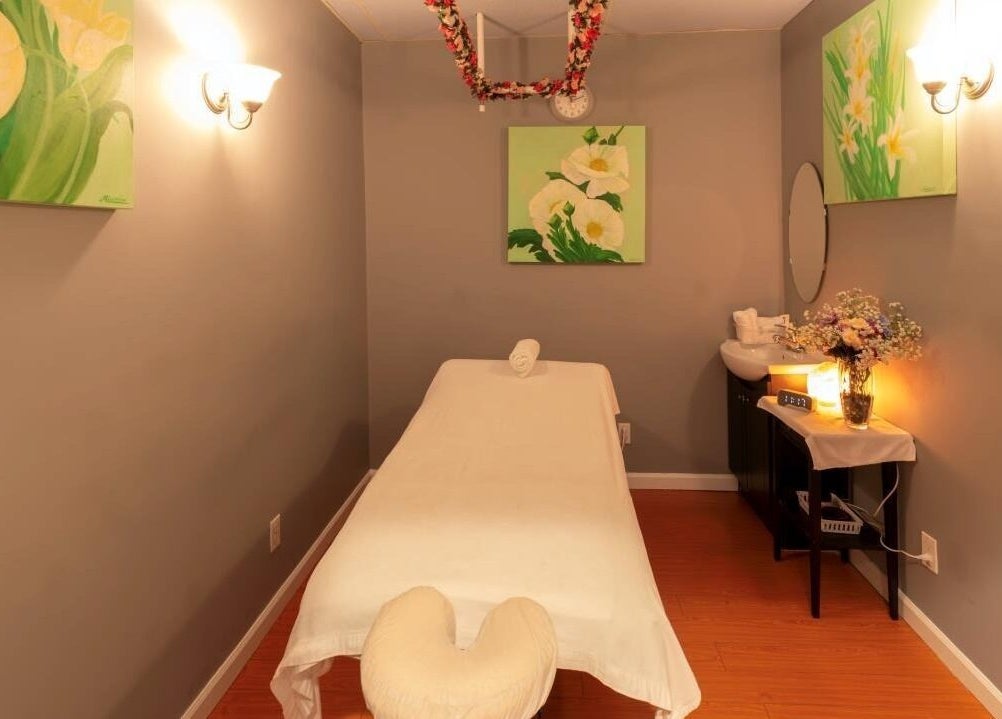 Relaxing massage room at Comfy Spa, Vancouver, British Columbia, CA. Soft lighting and floral decor enhance tranquility.