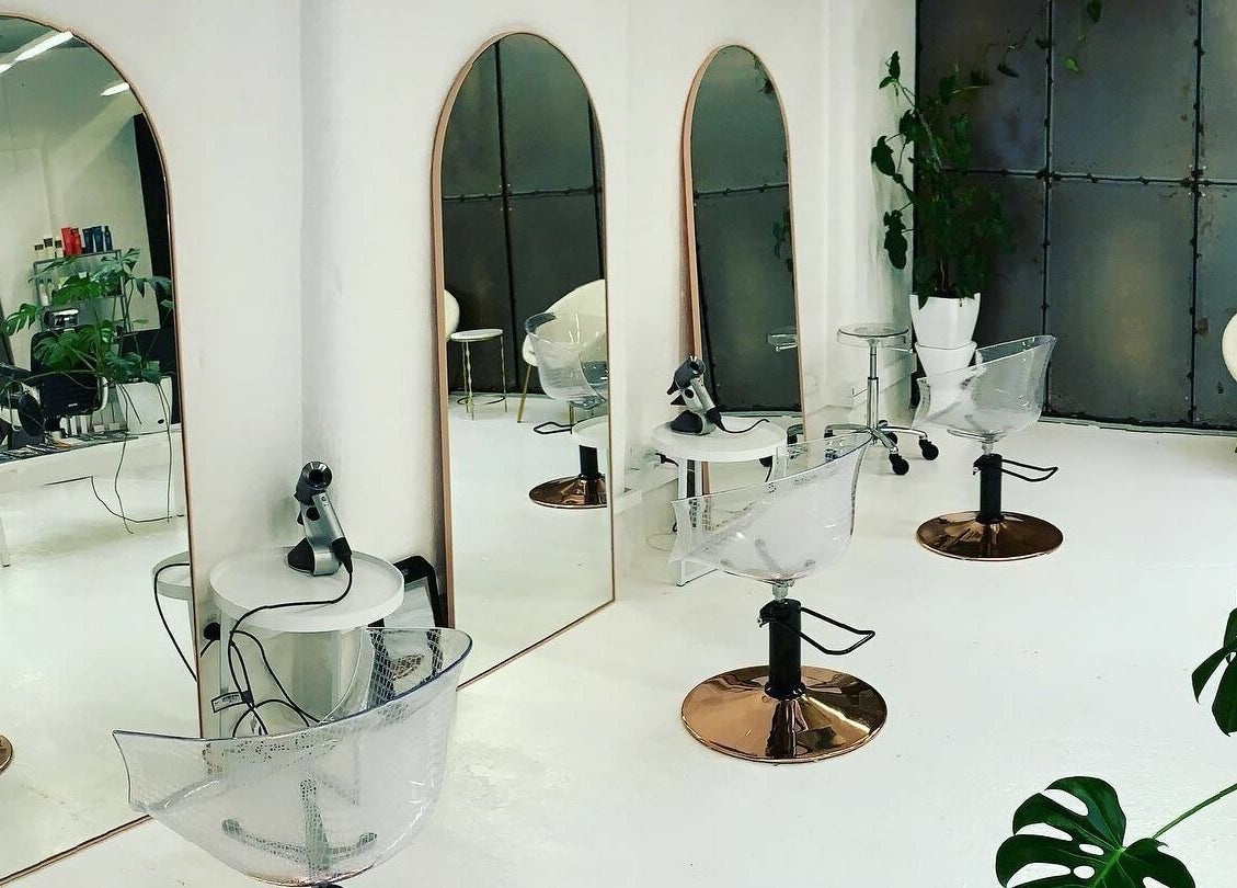 Modern salon interior at Worksense Haircutters in Melbourne, VIC, AU with sleek chairs and large mirrors.