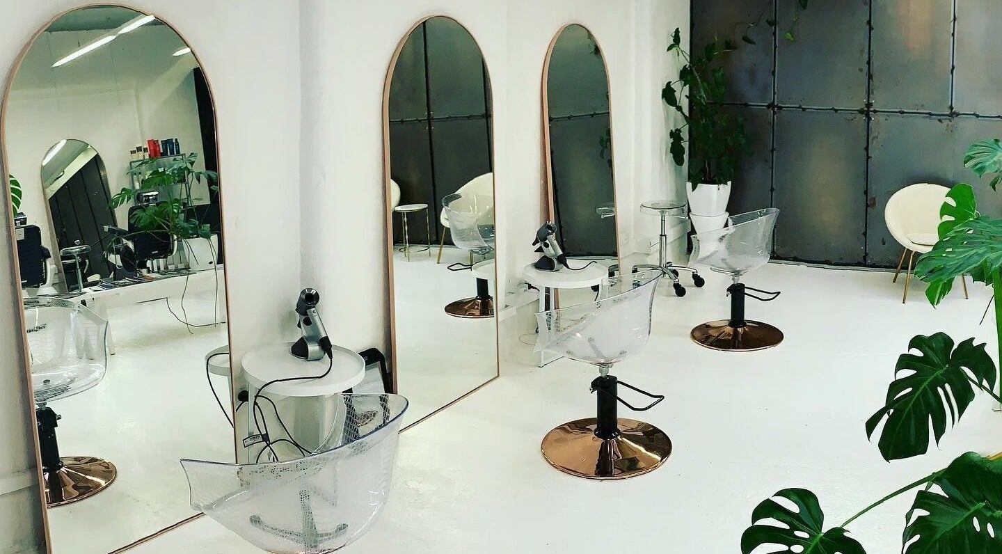 Modern salon interior at Worksense Haircutters in Melbourne, VIC, AU with sleek chairs and large mirrors.