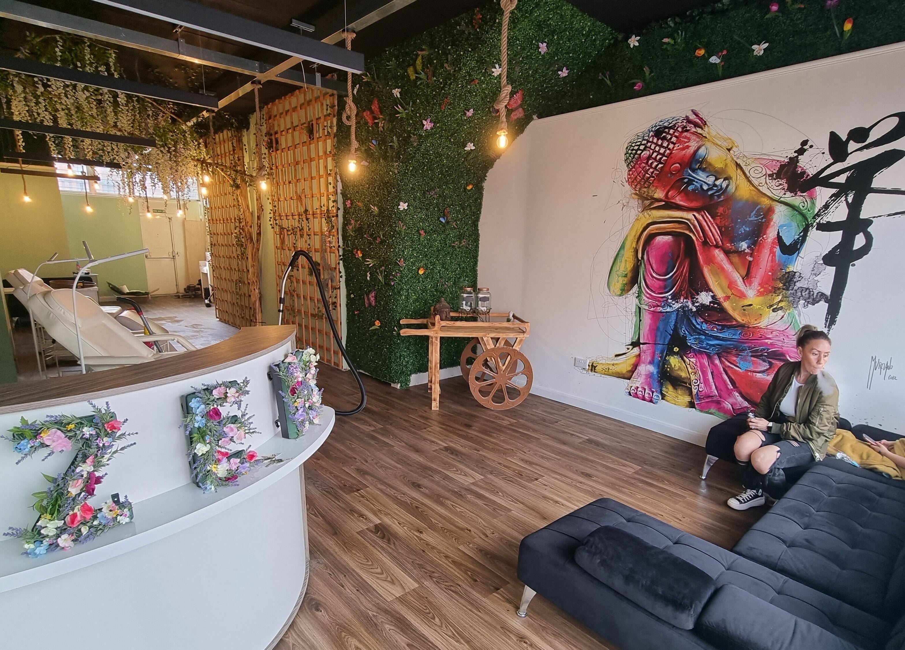 Lounge area at Zen Lashes And Beauty, Nottingham, England. Features colorful wall art and greenery decor.