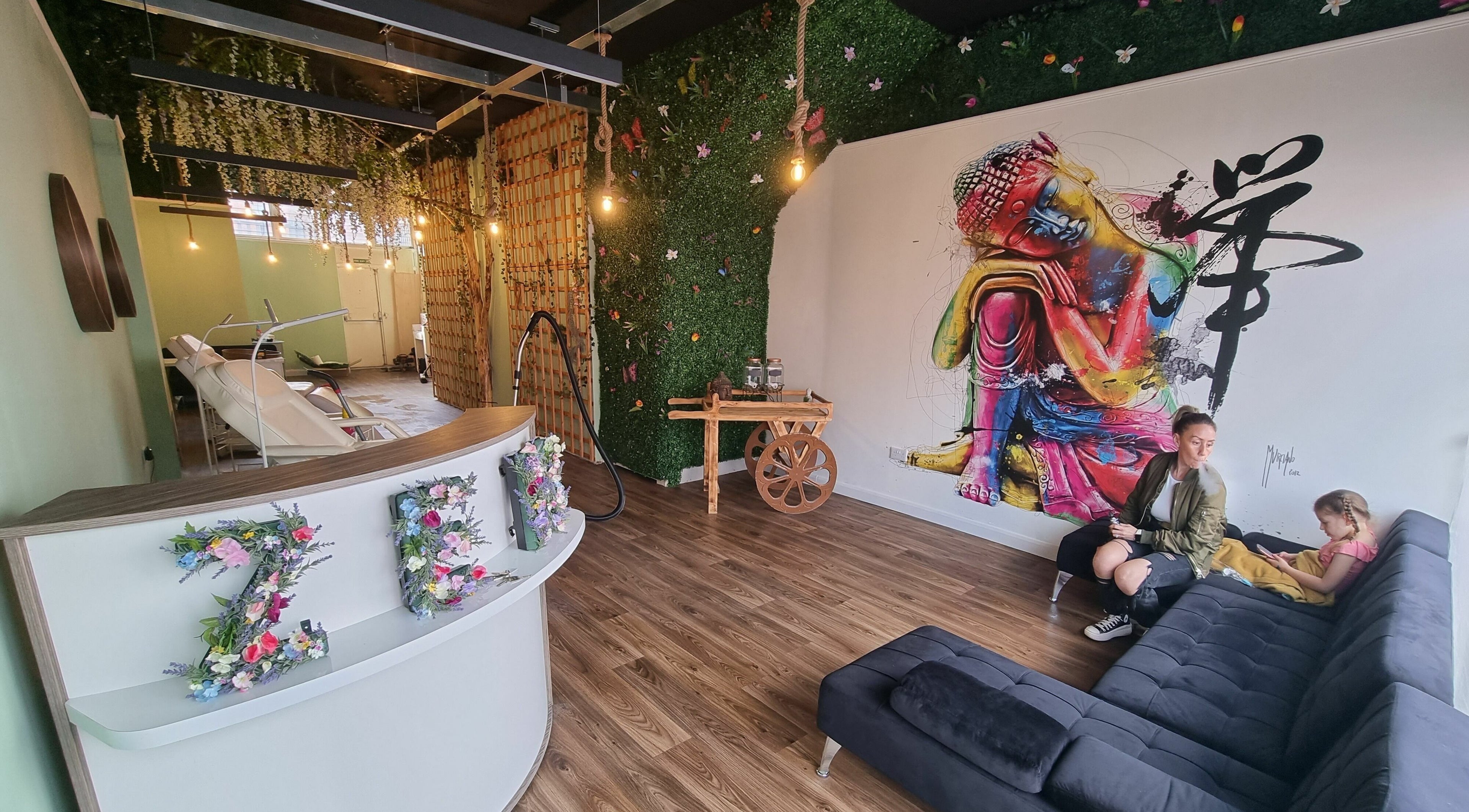 Lounge area at Zen Lashes And Beauty, Nottingham, England. Features colorful wall art and greenery decor.