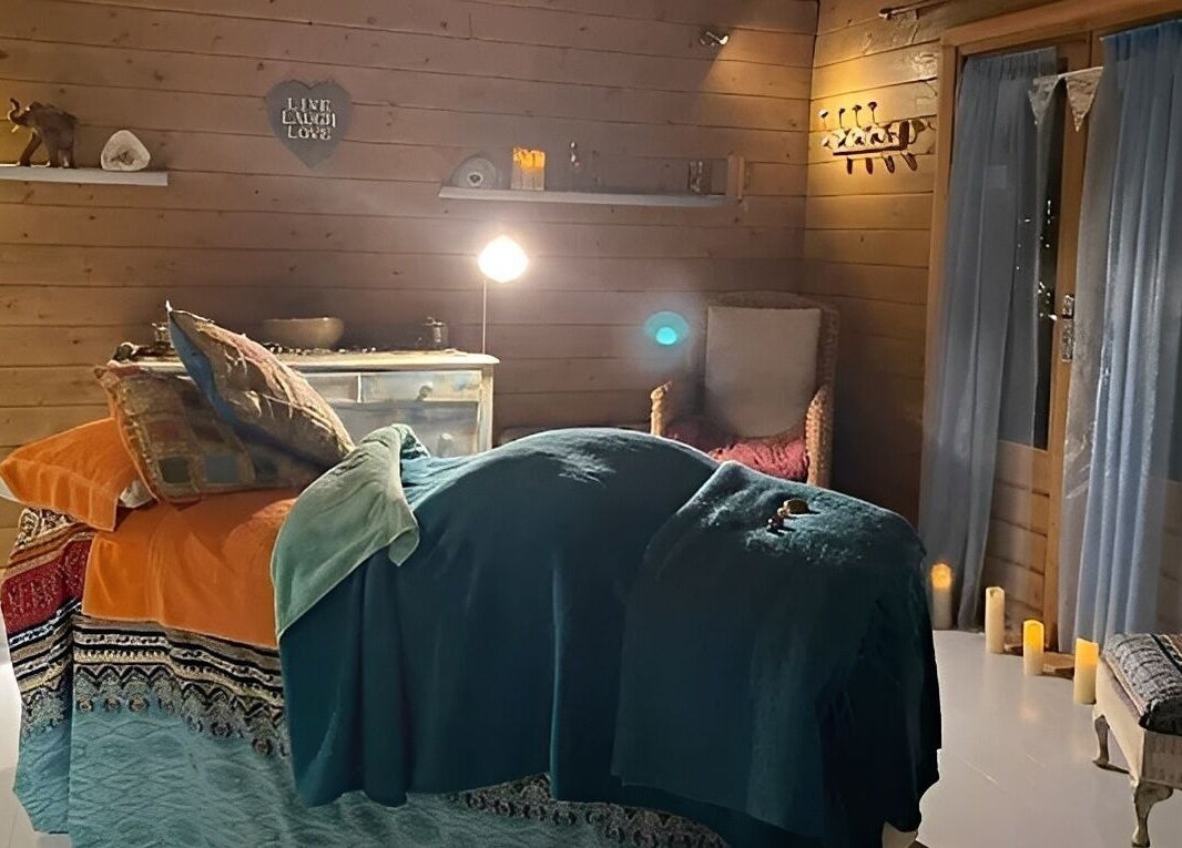 Cozy treatment room at Touching Lives in Hampton, England, GB, with soothing lighting and wooden decor.