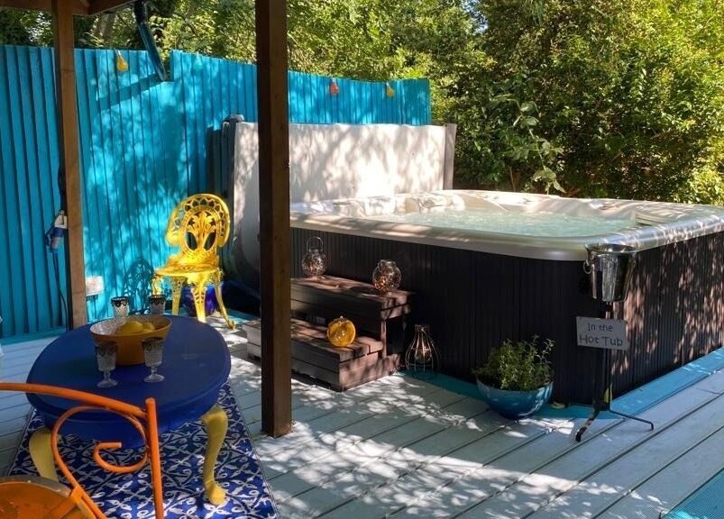 Outdoor spa at Touching Lives, Hampton, England, GB featuring a cozy hot tub and colorful seating area.