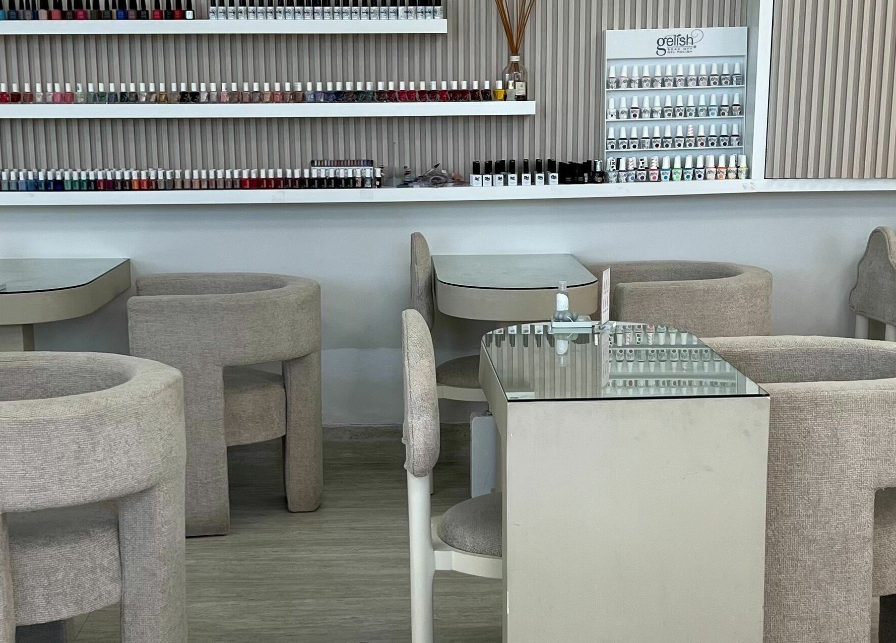 Chic nail salon interior at The Cloud Spa, Abu Dhabi, AE. Features plush seating and extensive nail polish display.