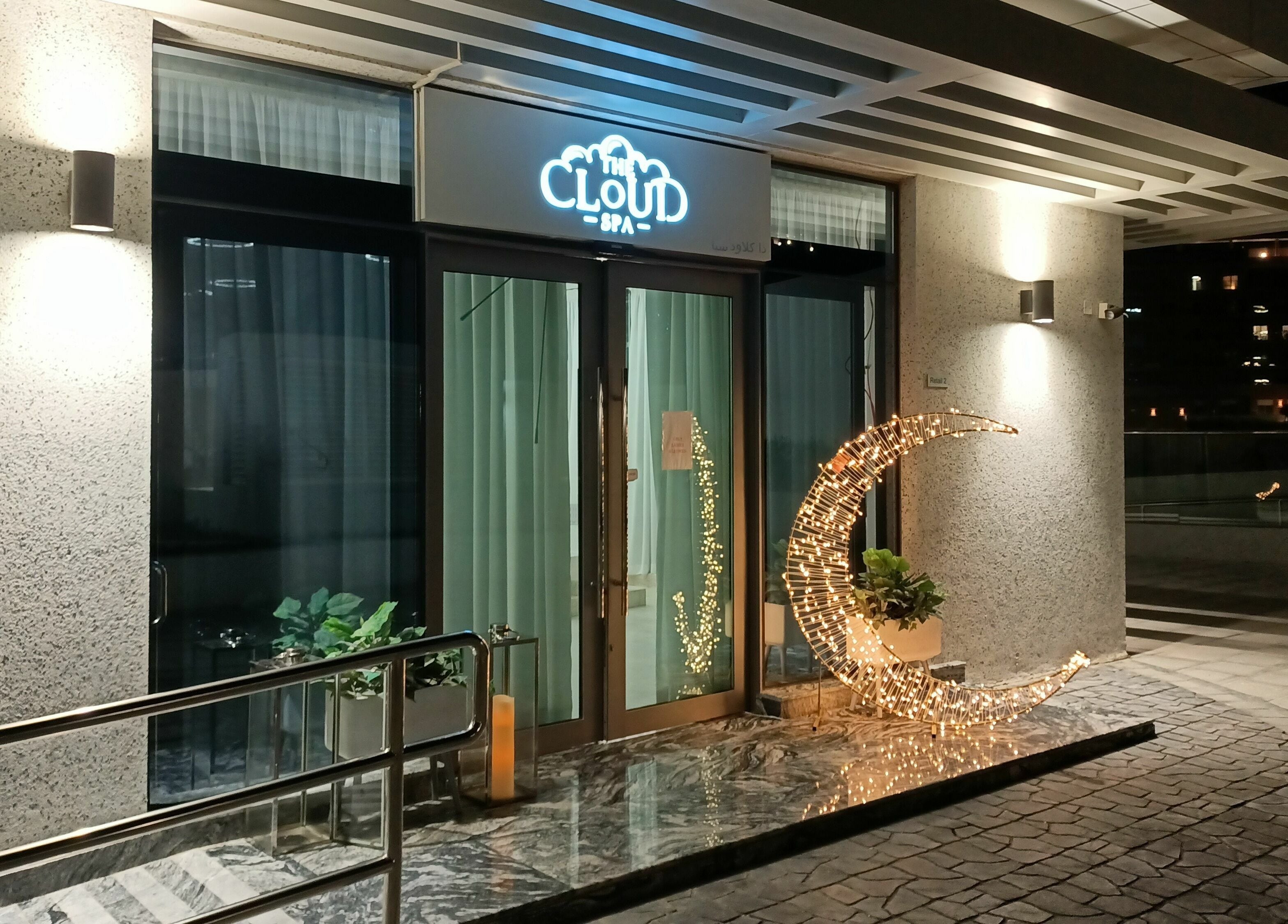 Elegant entrance of The Cloud Spa in Abu Dhabi, AE, featuring a glowing crescent sculpture and modern design.