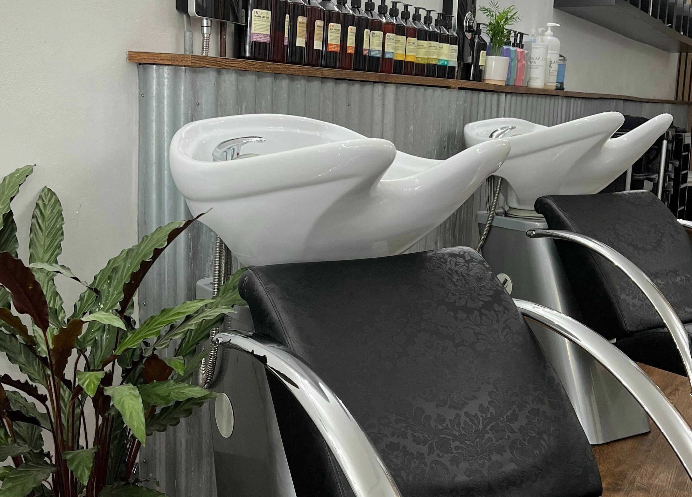 Elegant hair wash stations at Makeover Salon in Derby, England, GB, featuring modern design and lush greenery.