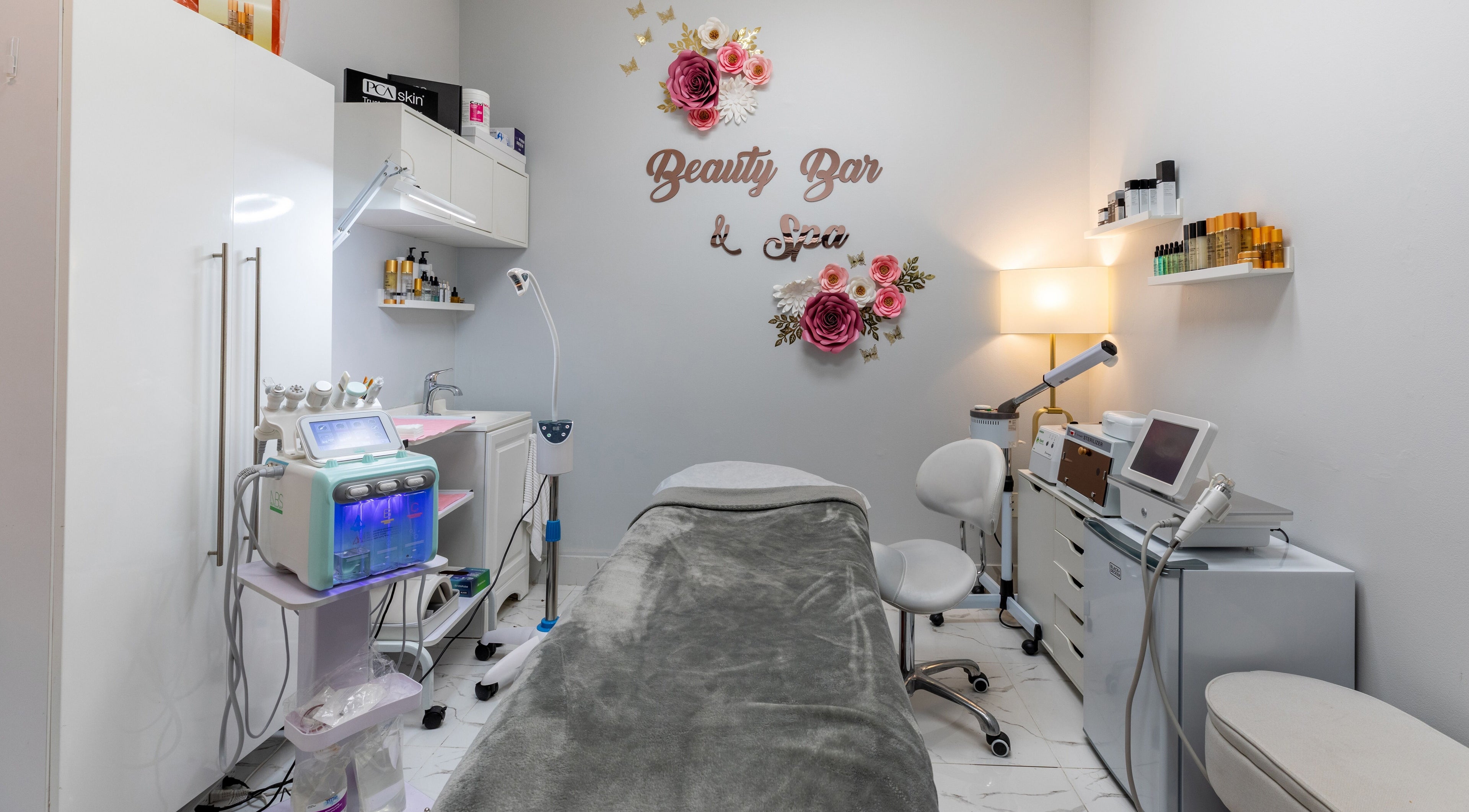 Relaxing treatment room at Beauty Bar & Spa, Miramar, Florida, US; spa bed and equipment visible.