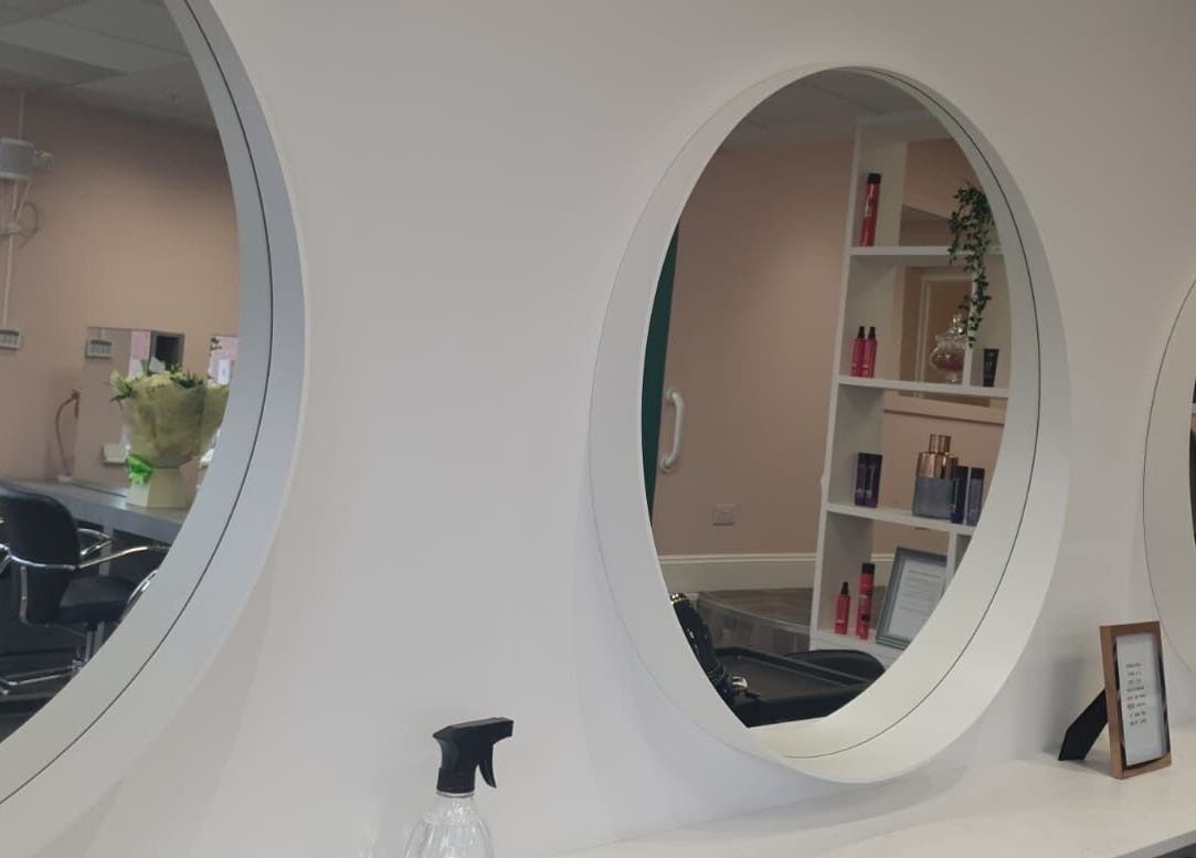 Modern salon interior with round mirrors at Chique Hair & Beauty, Carlisle, England, GB.