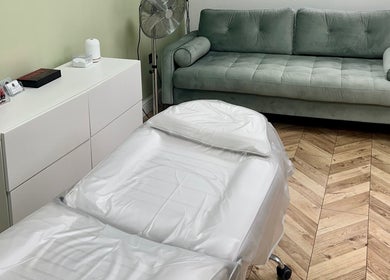 Relaxing treatment room at Arched And Dangerous Aesthetics, Dinas Powys, Wales, GB with a cozy couch.