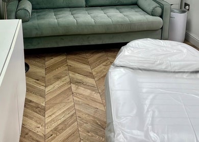 Modern treatment room at Arched And Dangerous Aesthetics in Dinas Powys, Wales, GB with cozy seating.