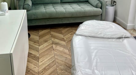 Modern treatment room at Arched And Dangerous Aesthetics in Dinas Powys, Wales, GB with cozy seating.