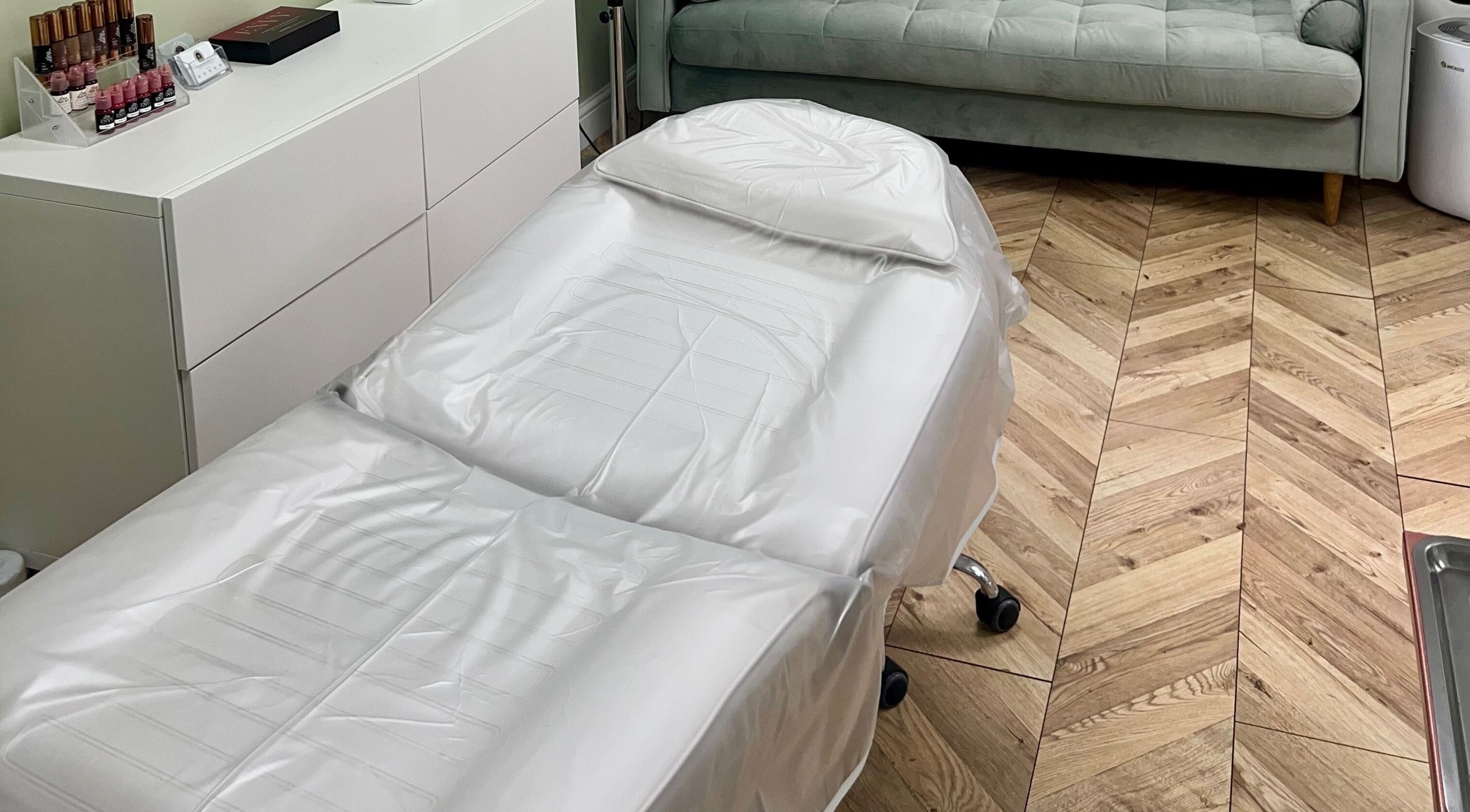 Modern treatment room at Arched And Dangerous Aesthetics, Dinas Powys, Wales, GB with sleek white furniture.