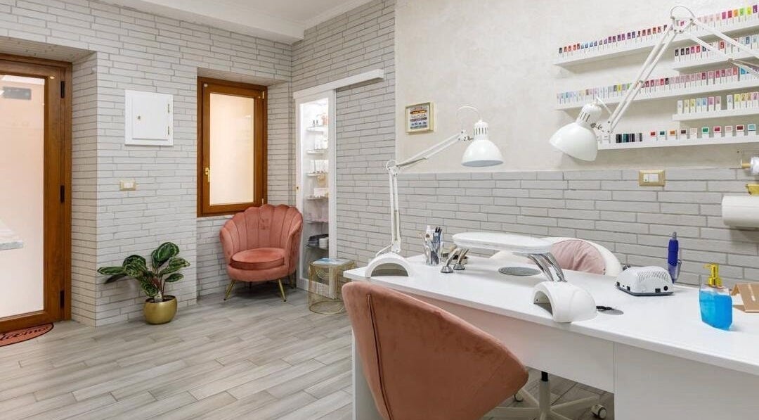 Interno elegante di Studio Nails Di Stefania Portas, Iglesias, Sardegna, IT. Arredo moderno e poltrone rosa.