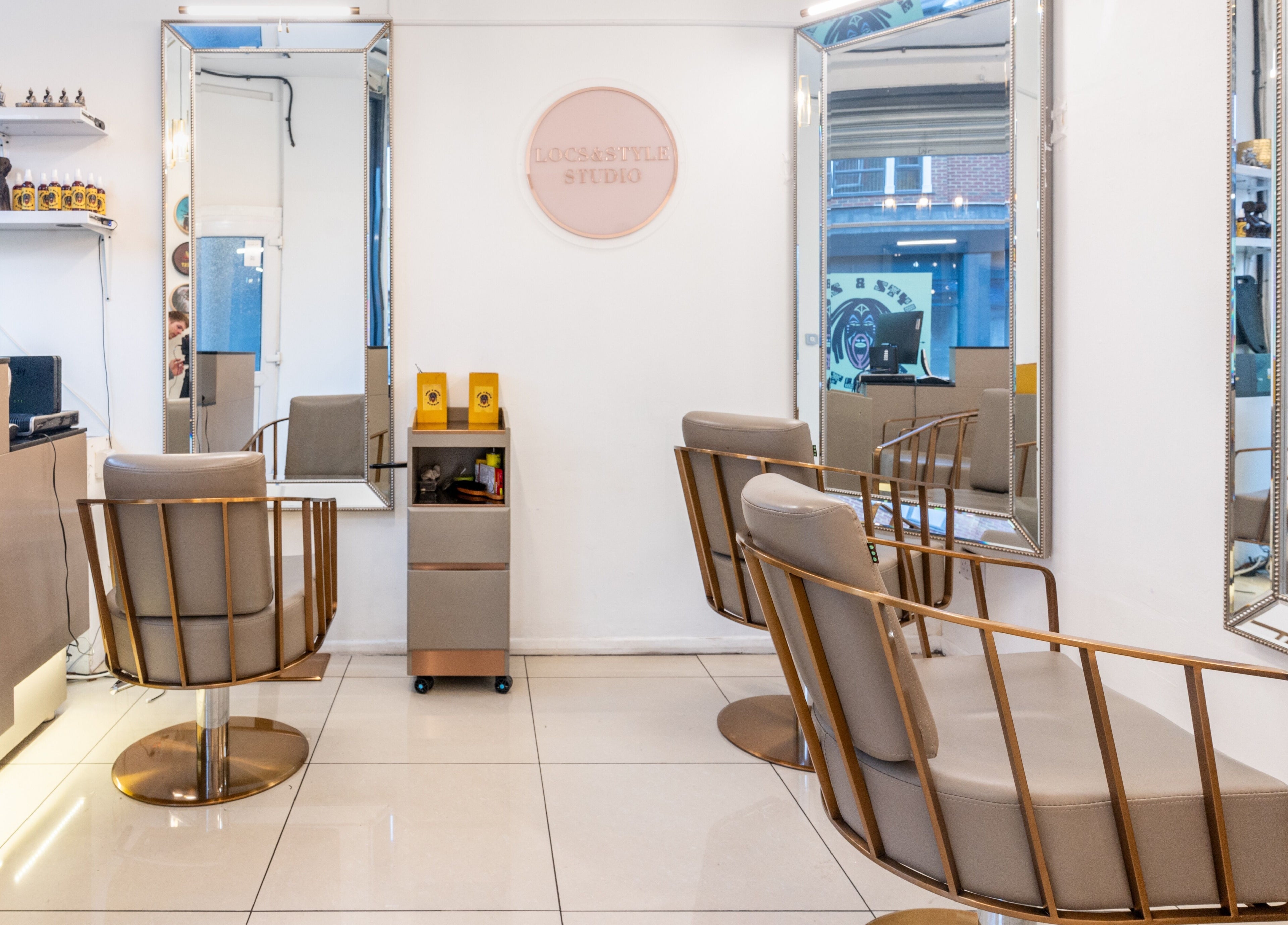 Modern salon interior at Locks & Style Studio, London, England, GB featuring sleek chairs and large mirrors.