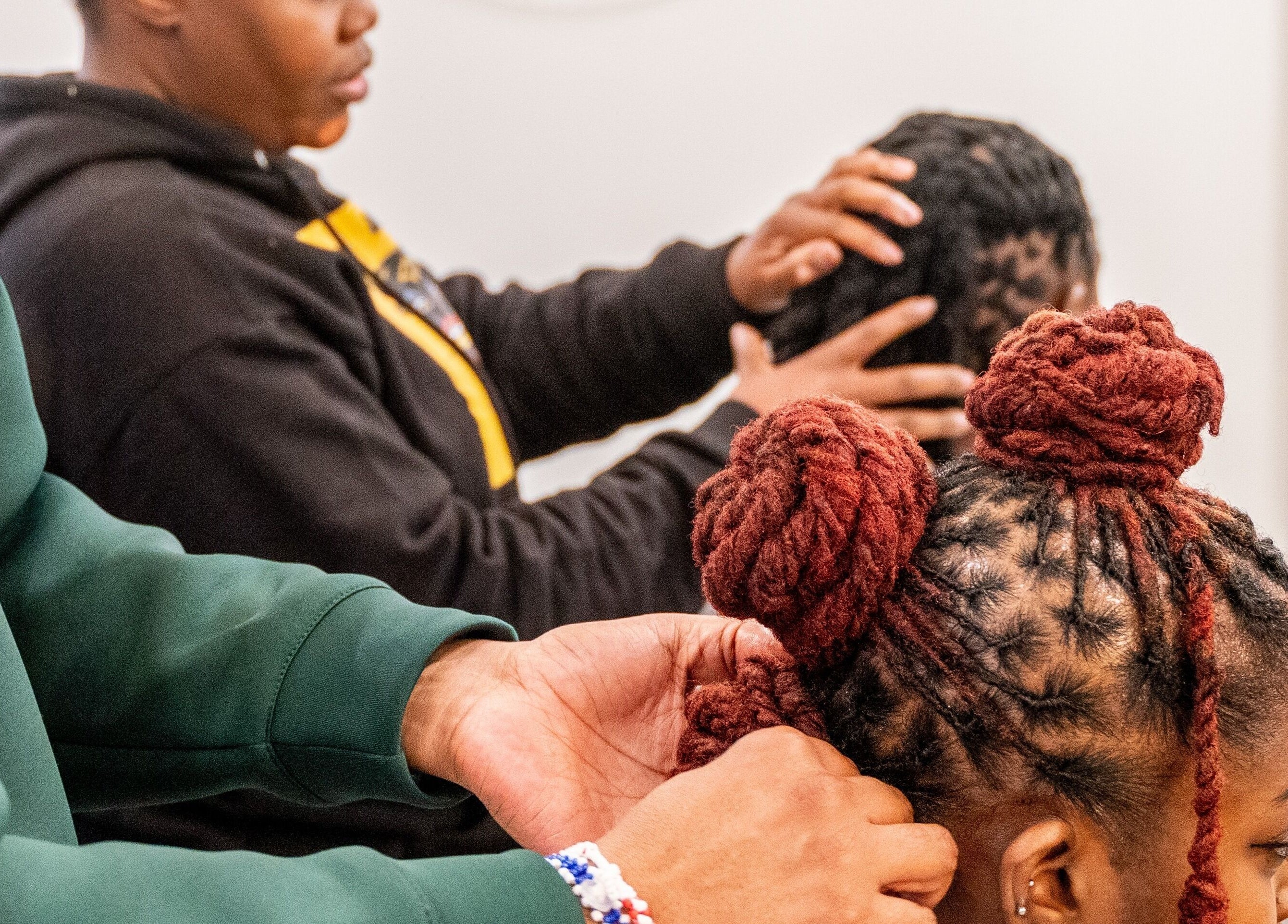 Stylists creating intricate braids at Locks & Style Studio, London, England, GB.