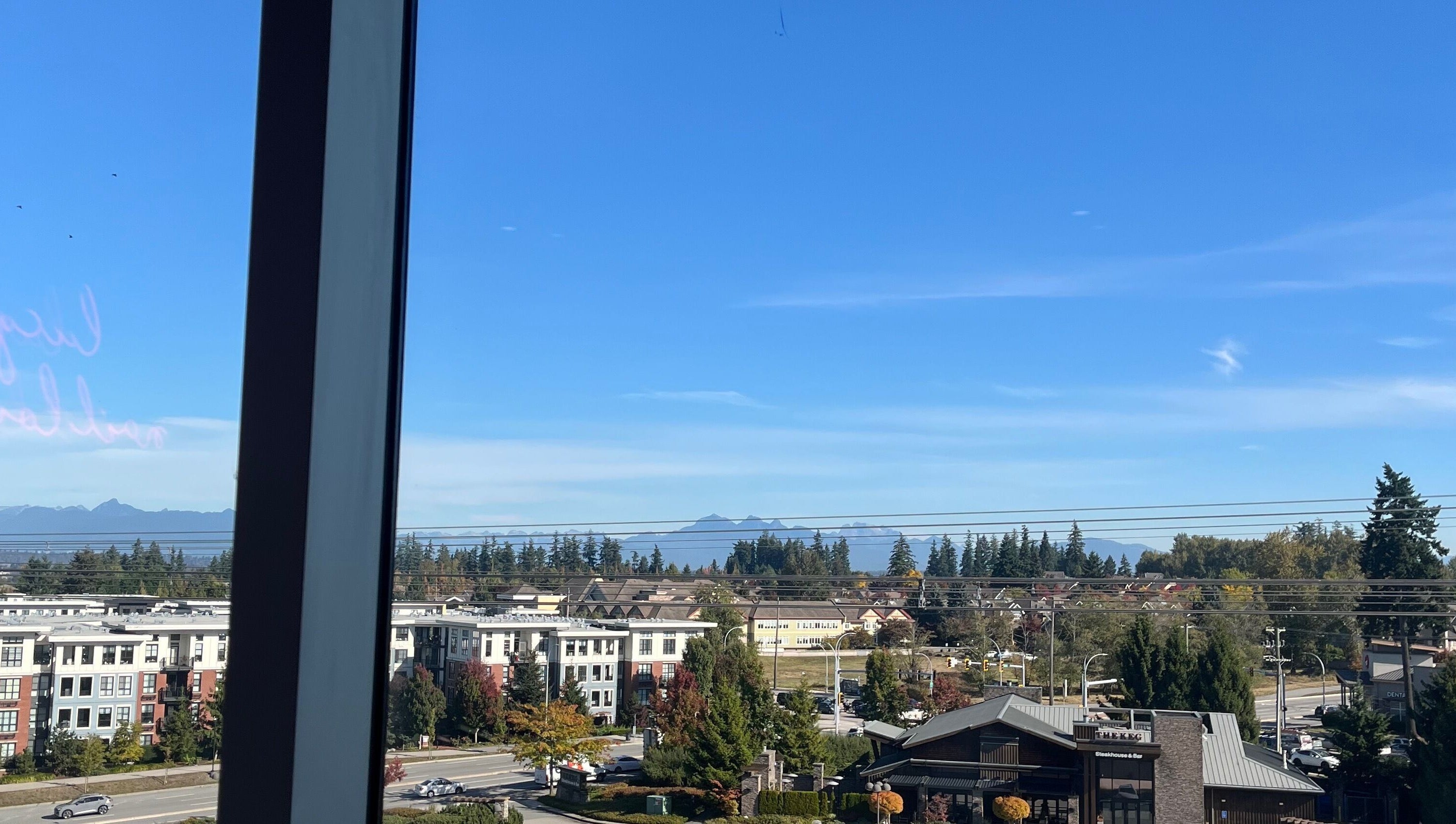 View from Refine Manicure Studio Surrey, BC, showcasing mountains and cityscape with clear skies.