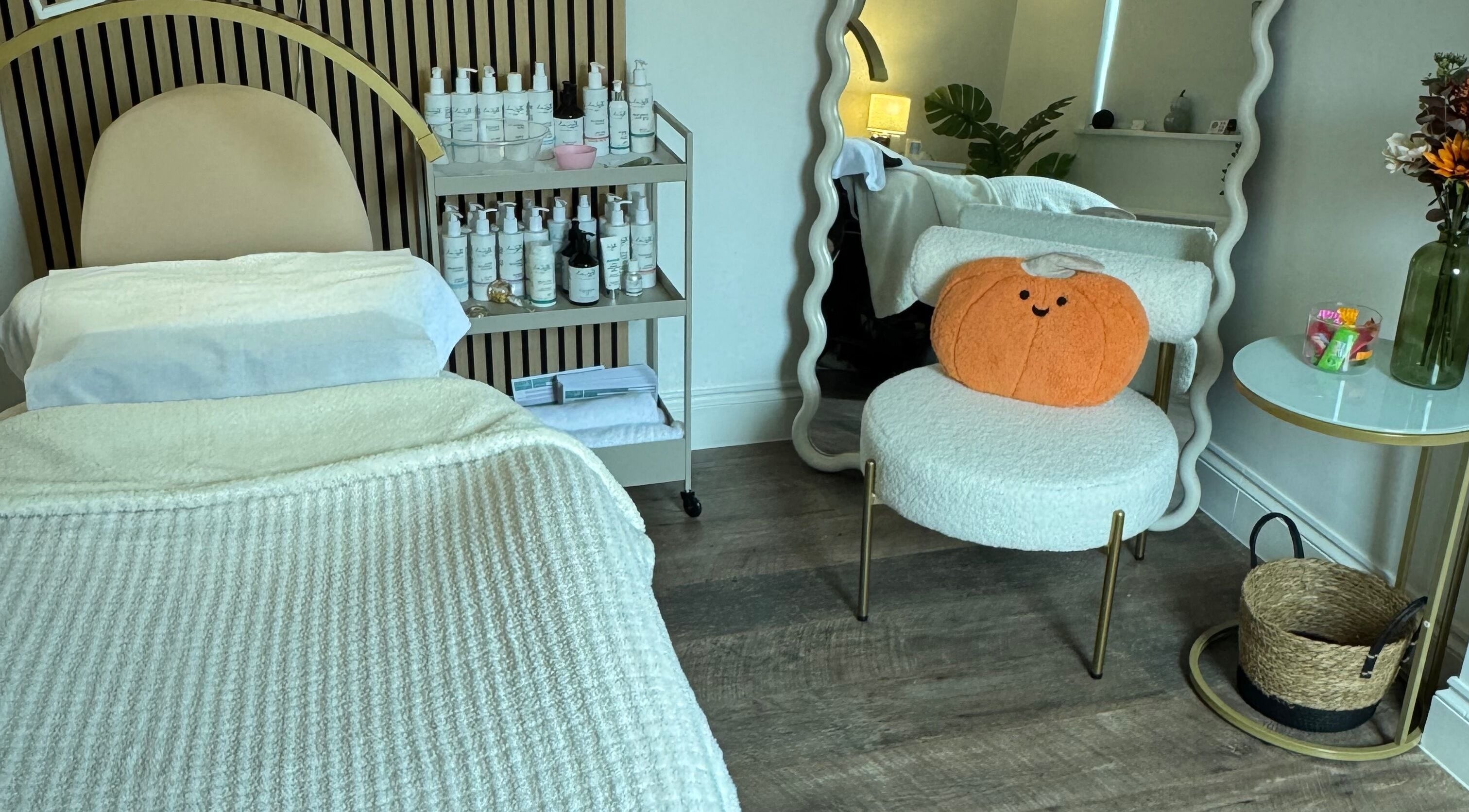Cozy treatment room at Gems Beauty Clinic, Bedford, England, GB with plush decor and skincare products.